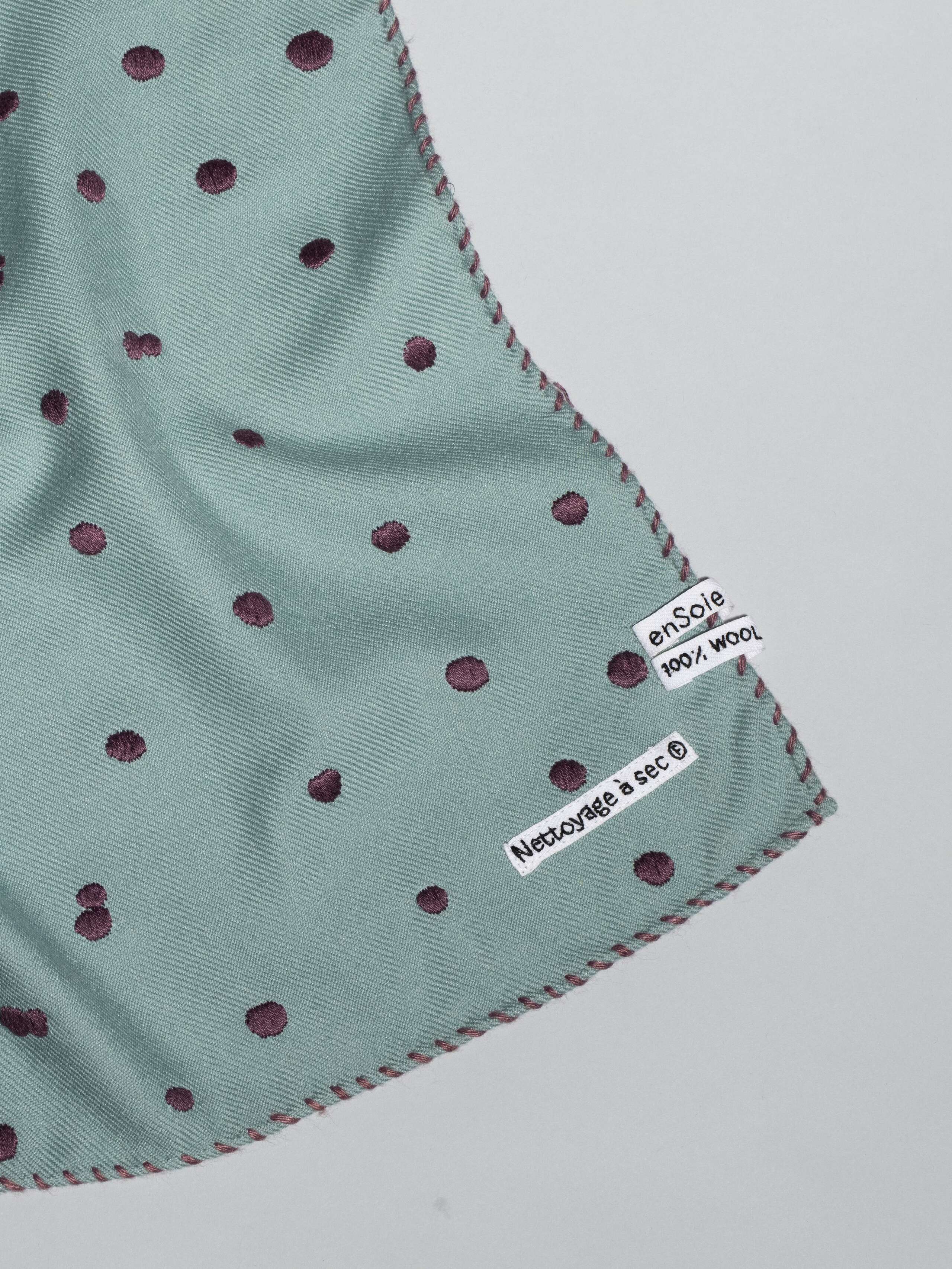 details of Leo wool scarf with dots in a light bluish rosemary green an purple embroidery
