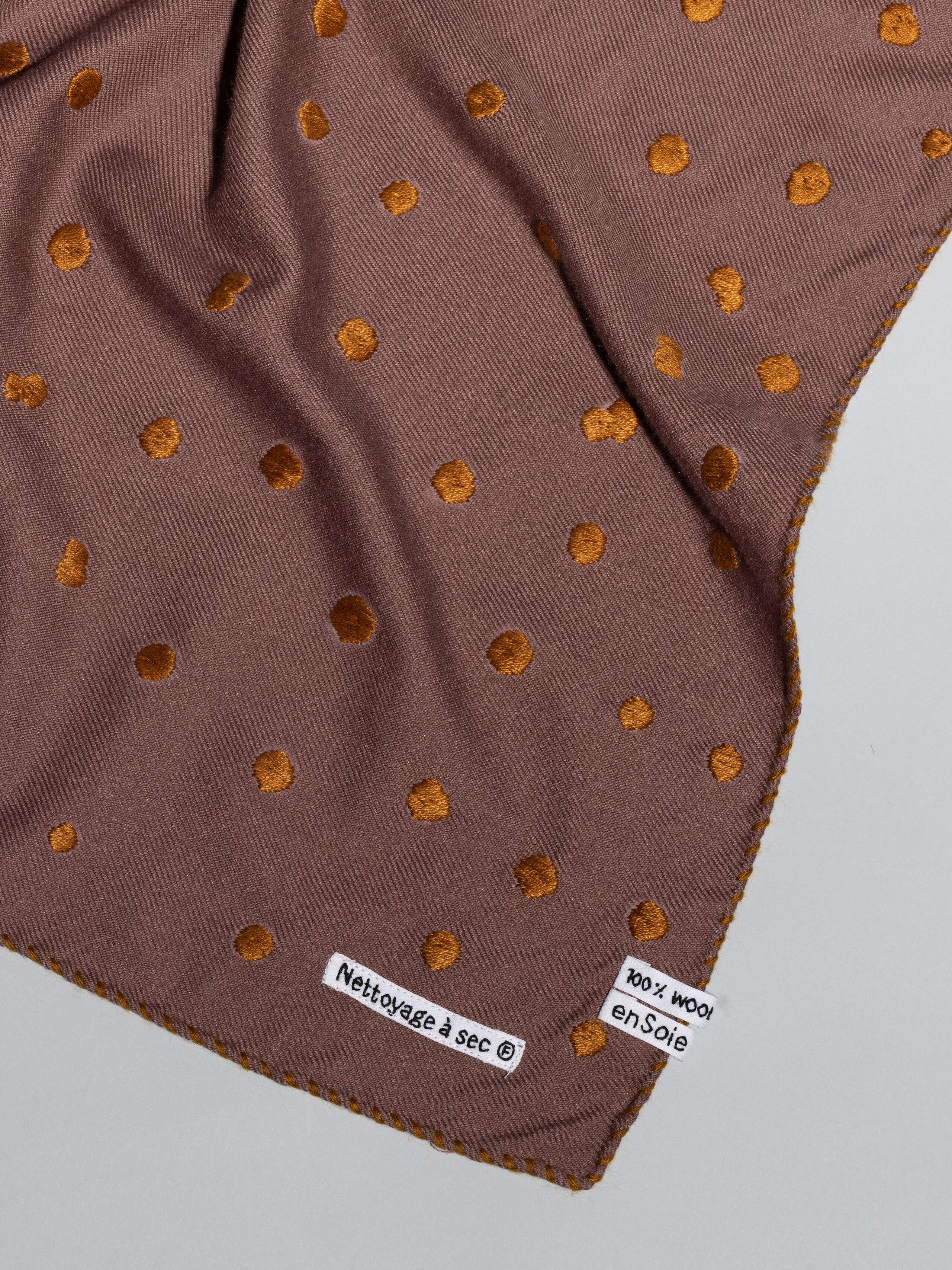 details of Leo wool scarf in a warm cherry wood purple with dot embroidery in warm bronze shades