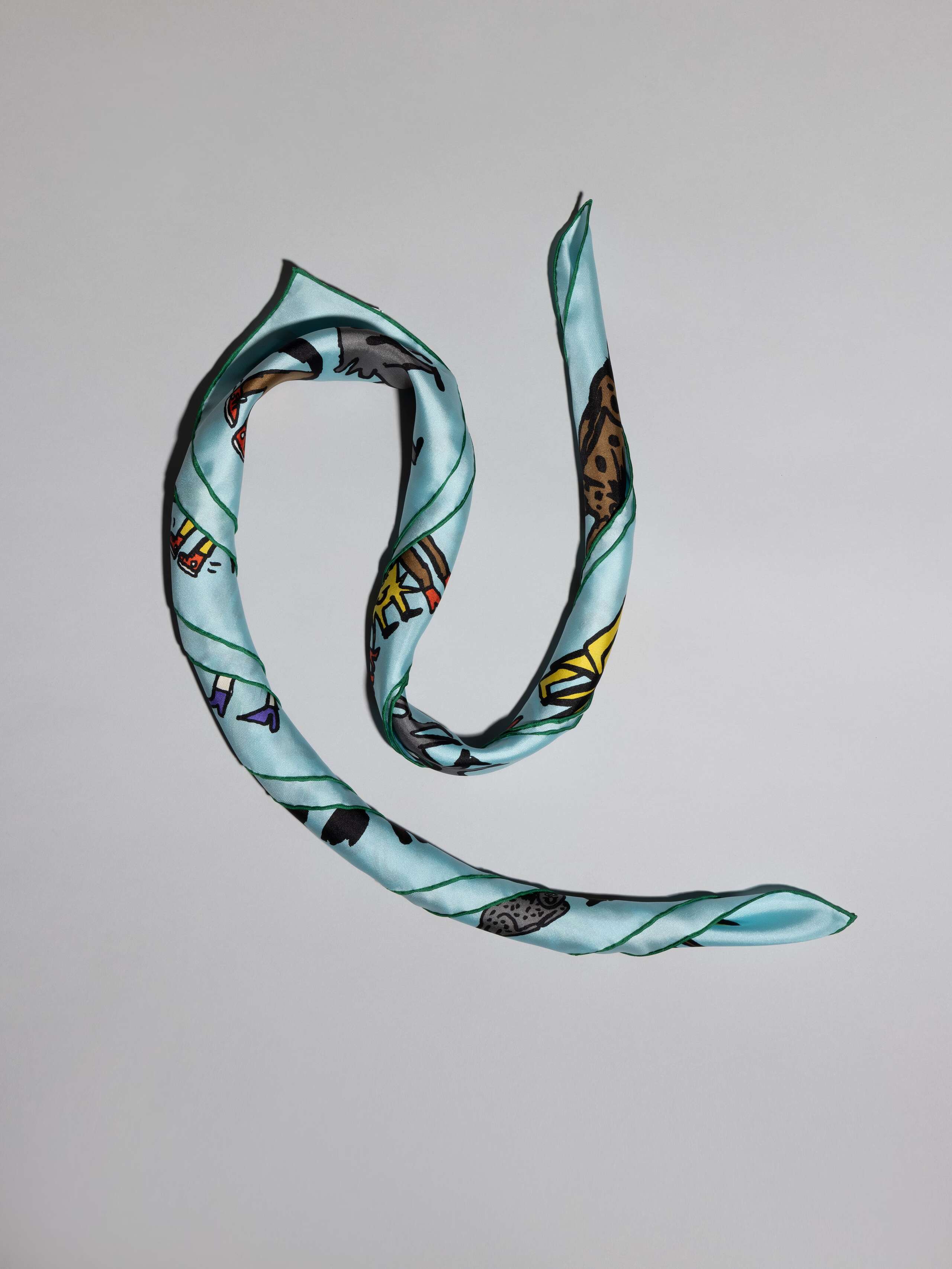 silk foulard in light blue with ojo de agua sun signature print detail rolled
