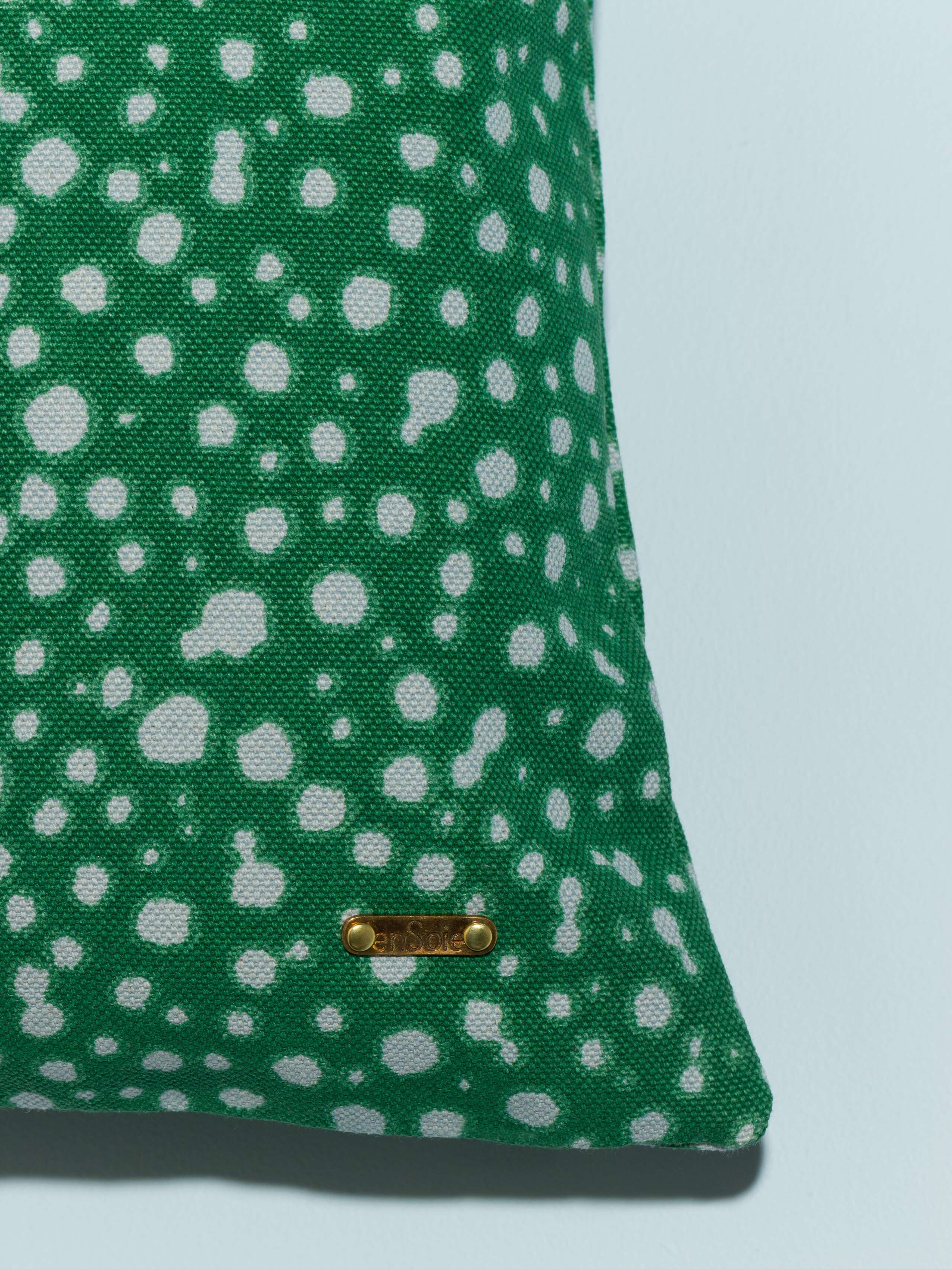 pillow cover in green with light blue leo dots detail shot brass