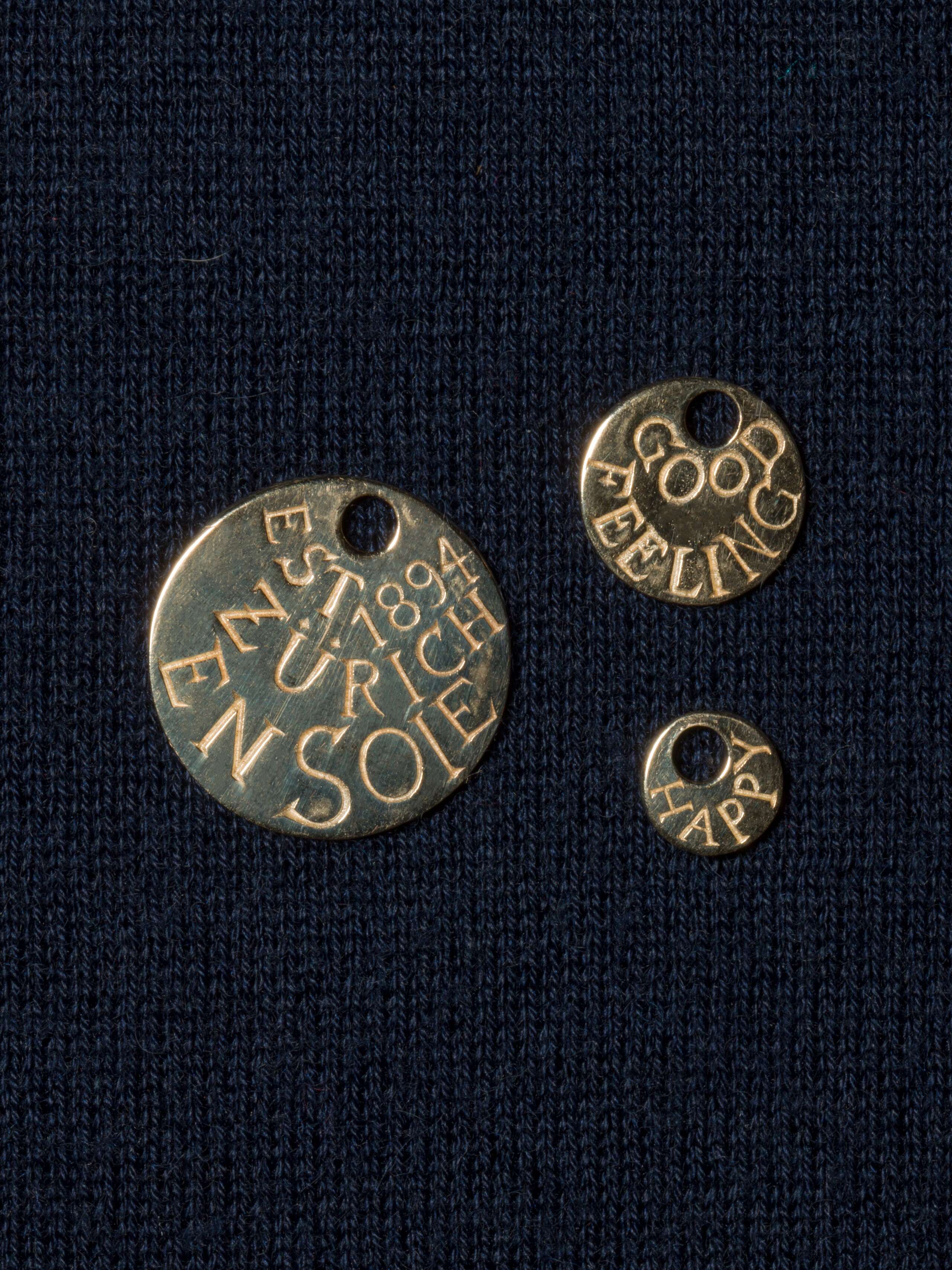 three engraved round tags in gold packshot
