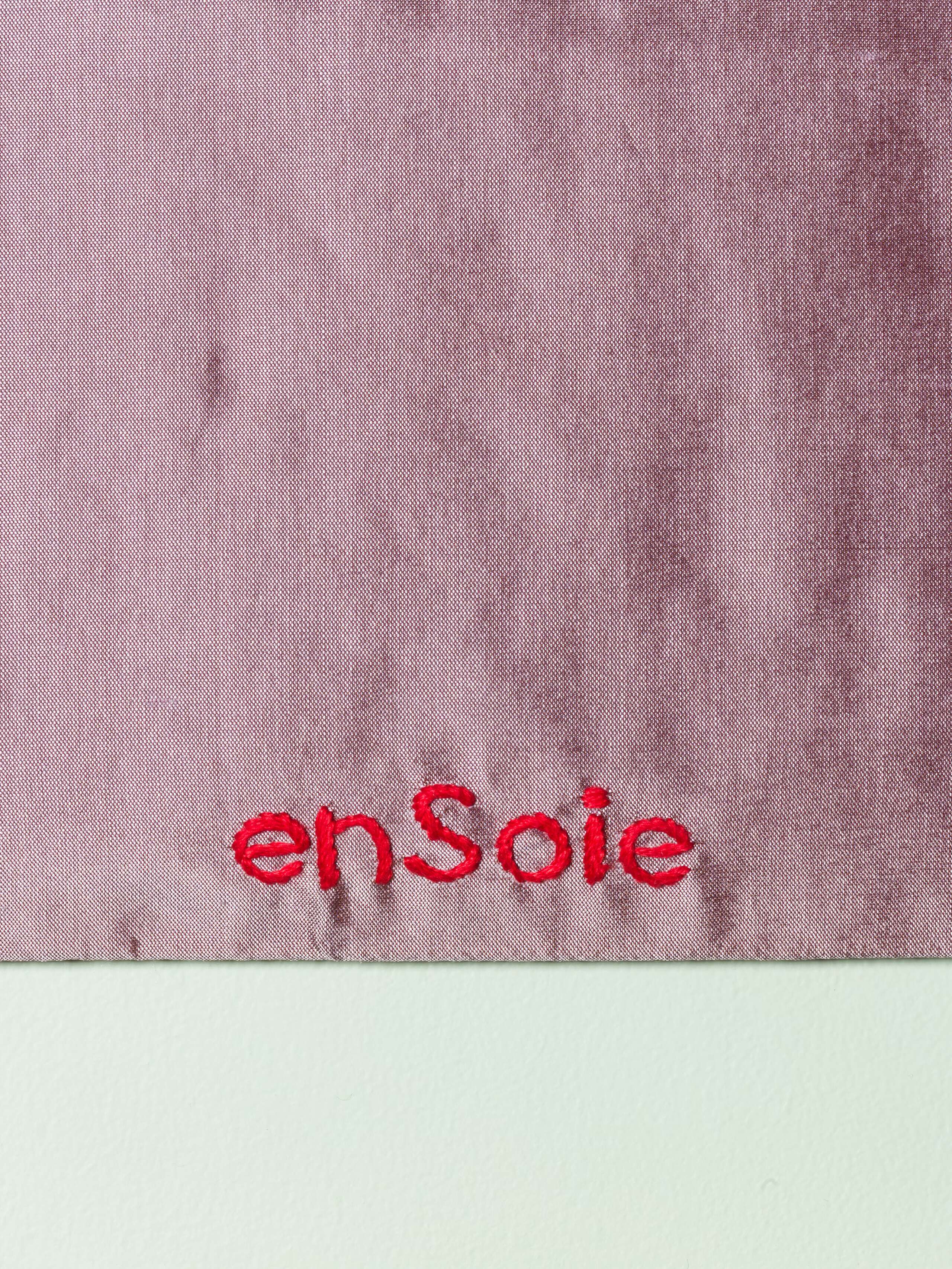 Details of a beautiful silk clutch in a vibrant lavander purple with a pearly gloss and beautiful embroidery LOVE RULES FOREVER in red