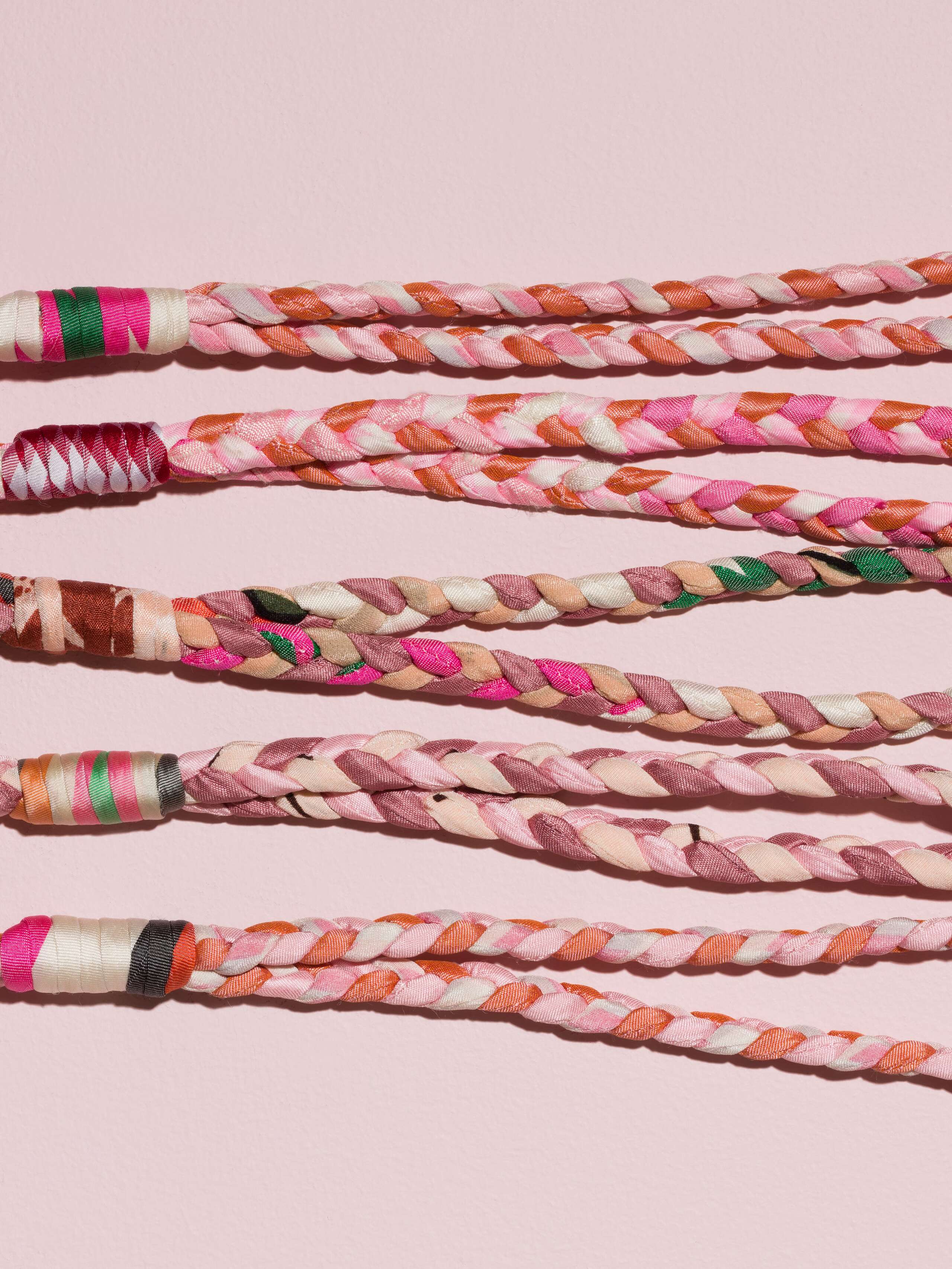 details of four braided keychains in rose shades in silk