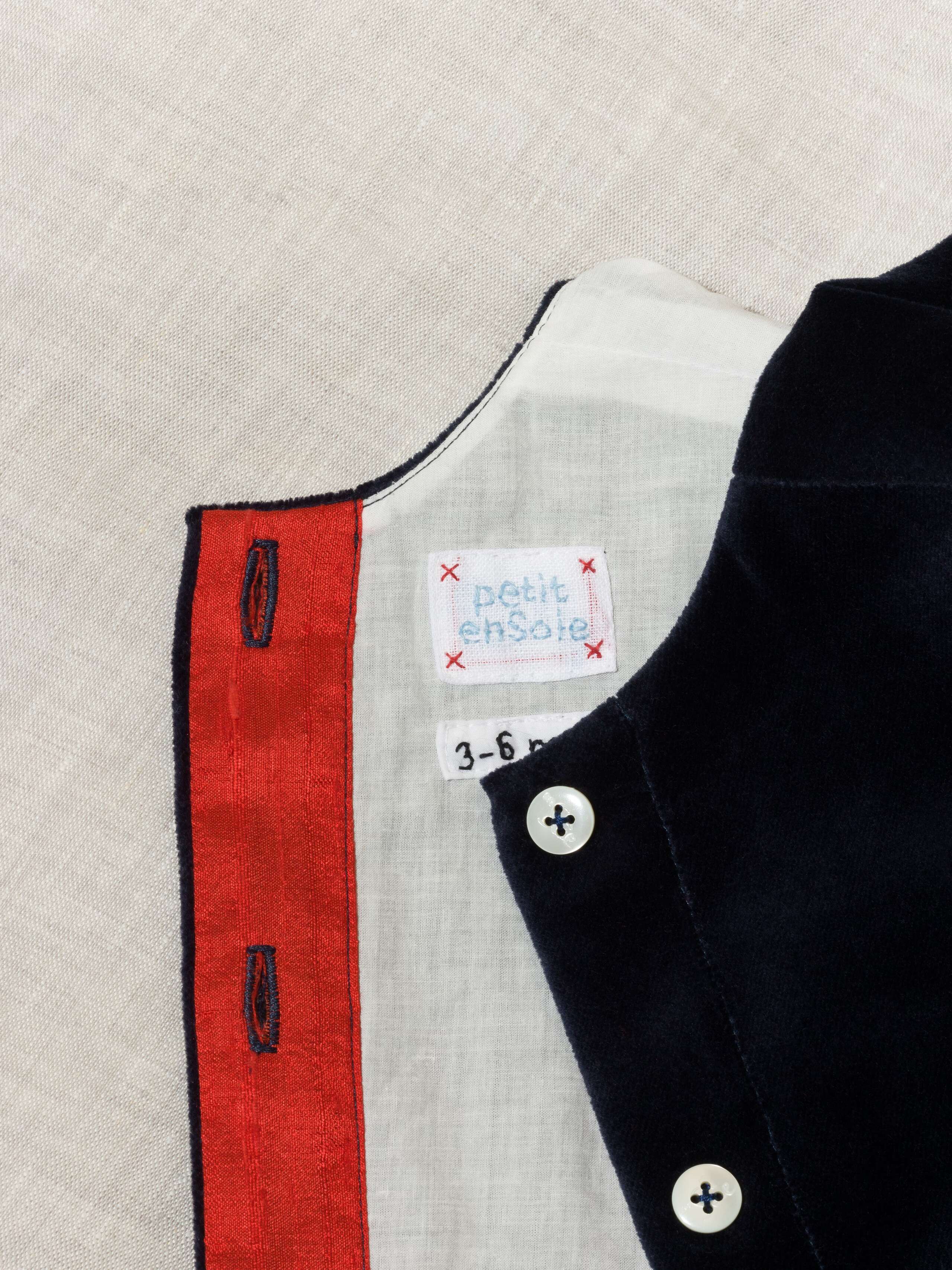 Detail of beautiful cotton velvet baby dress sleeveless with red silk bow handmade in Zurich, navy cotton velvet