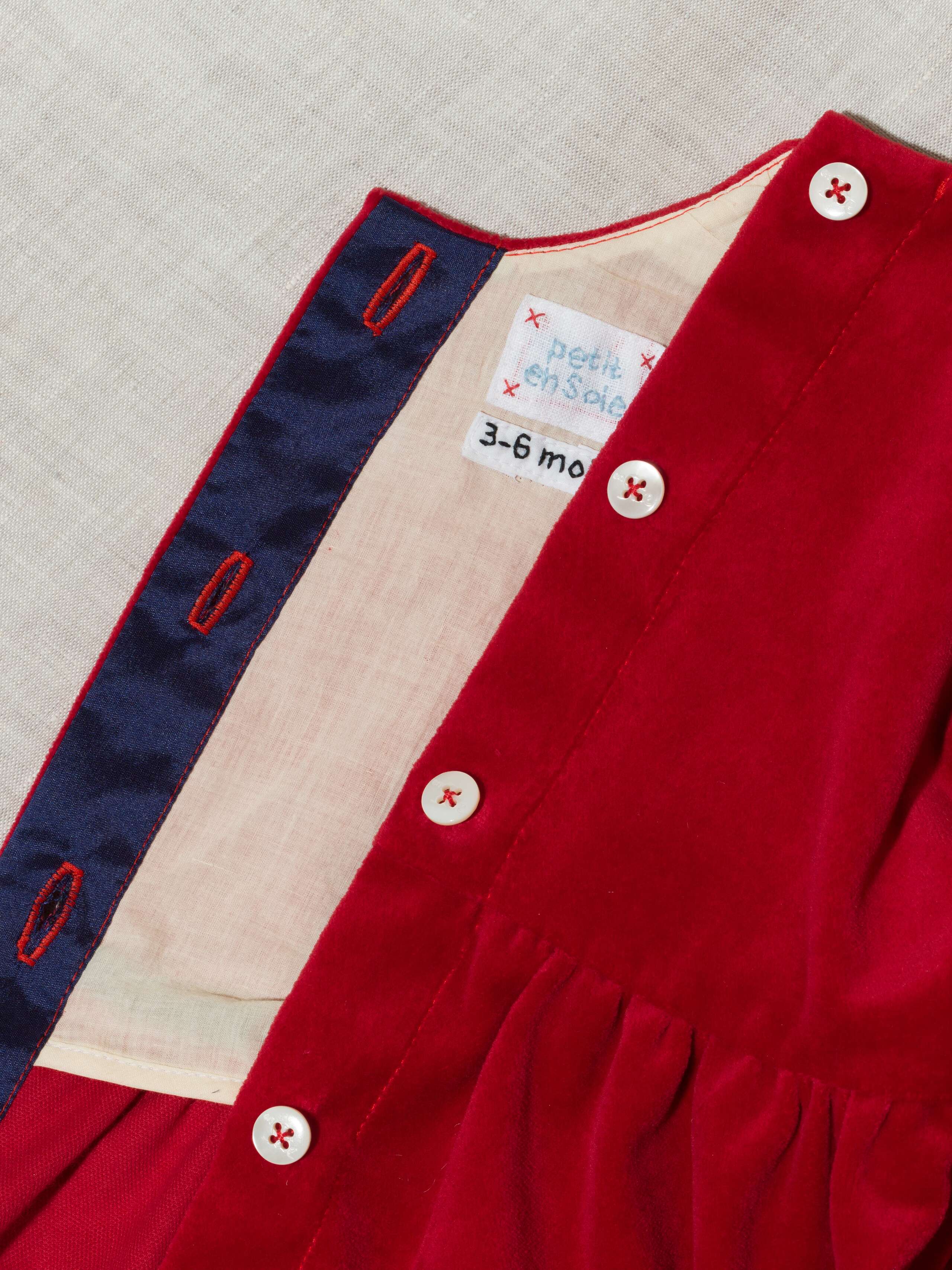 Detail of beautiful cotton velvet baby dress sleeveless with navy silk bow handmade in Zurich, red cotton velvet