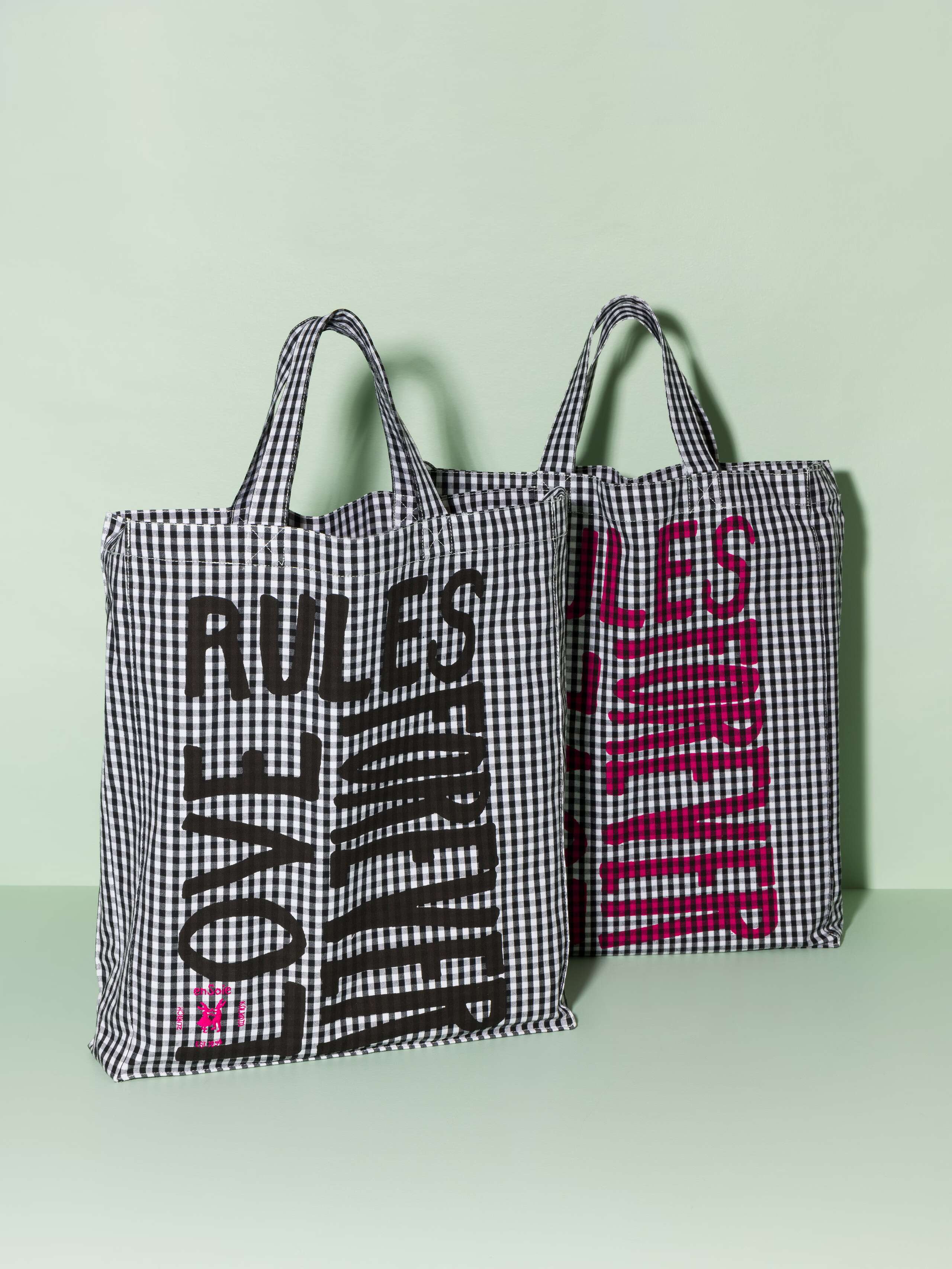 Two cotton tote bags with a black vichy pattern and a black and pink print that says "Love rules forever"