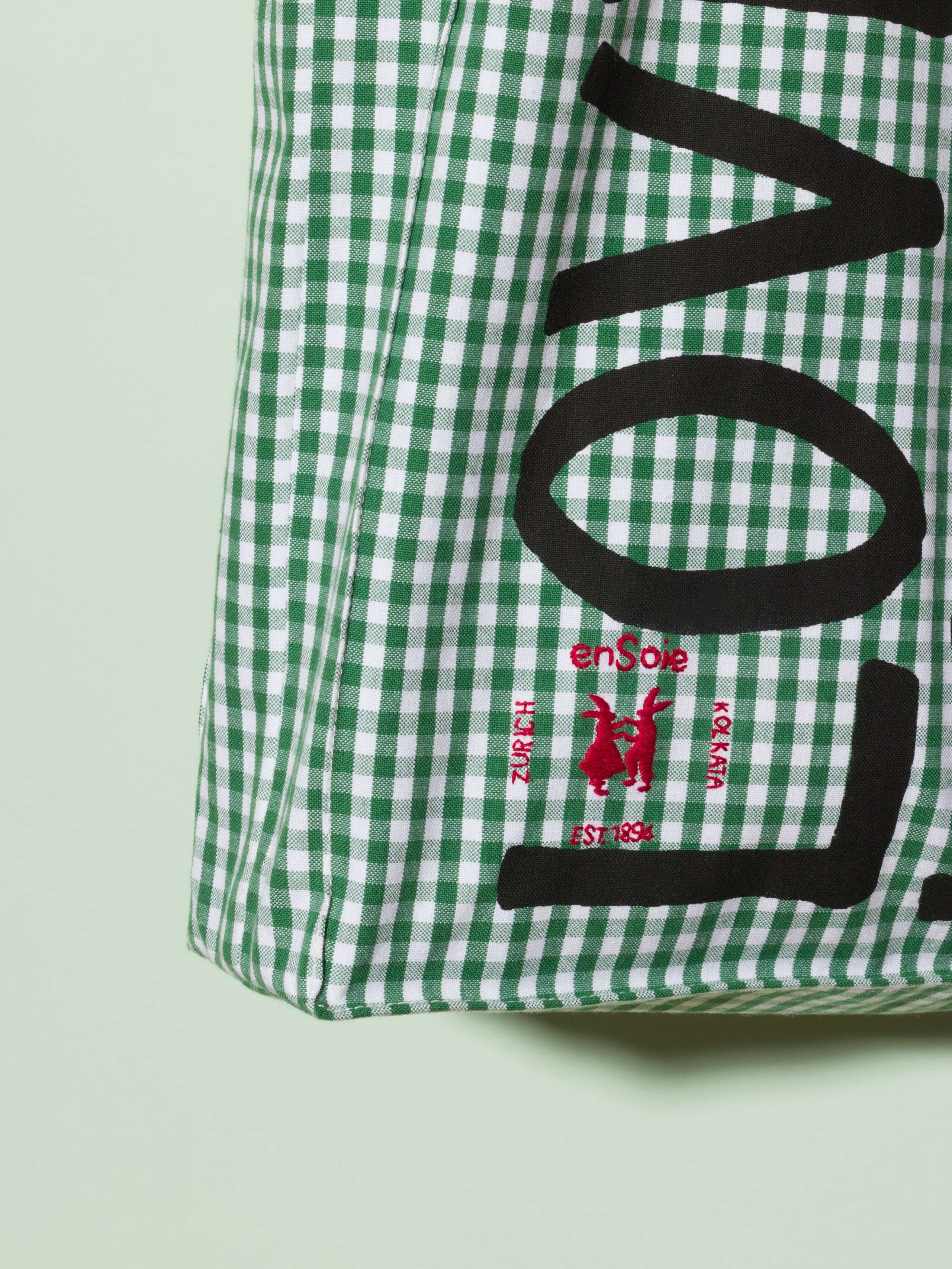  cotton tote bag with a green vichy pattern and a black print that says "Love rules forever" and a rabbit ebroidery