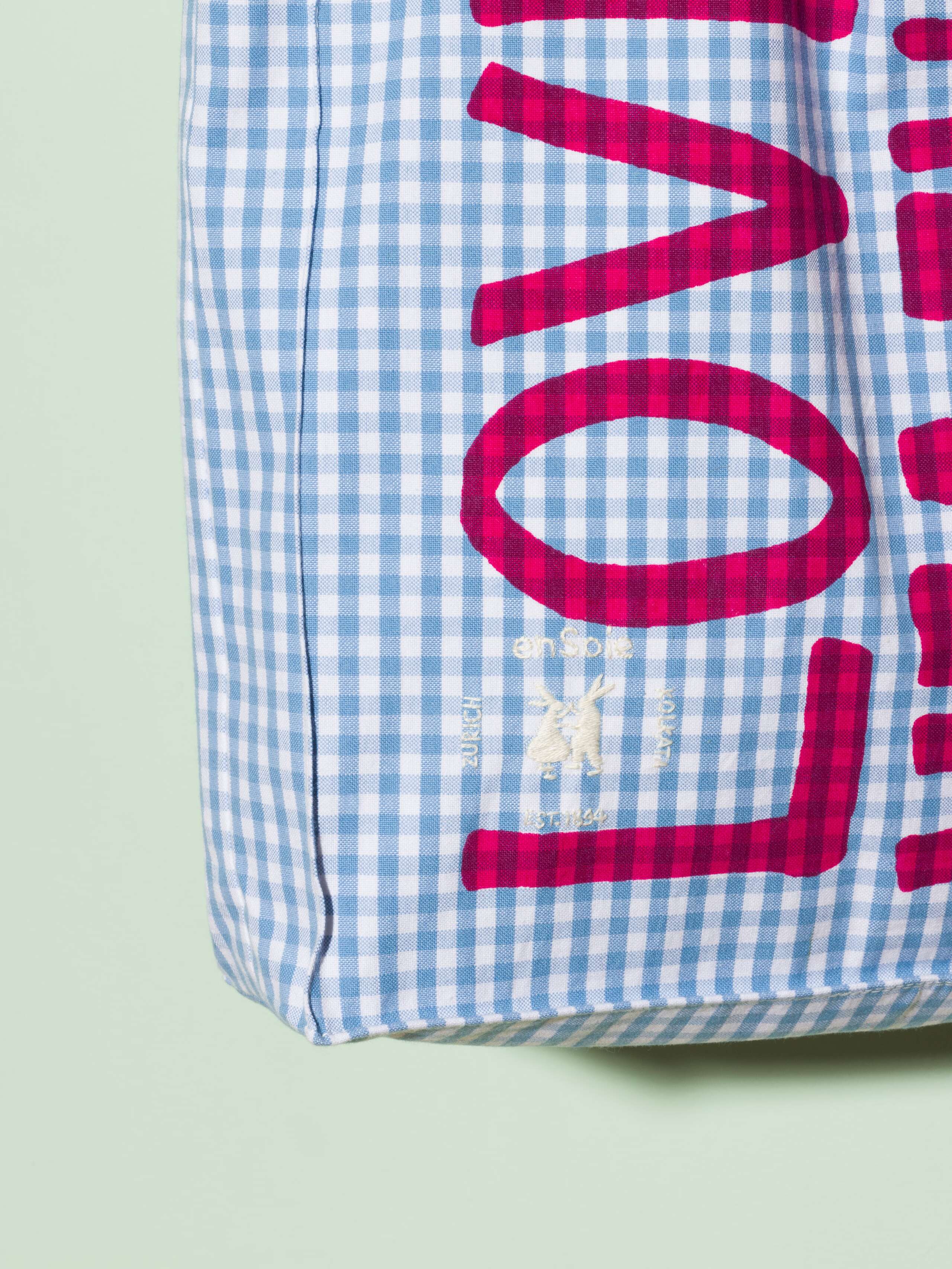  cotton tote bag with a light blue vichy pattern and a pink print that says "Love rules forever" and a rabbit ebroidery