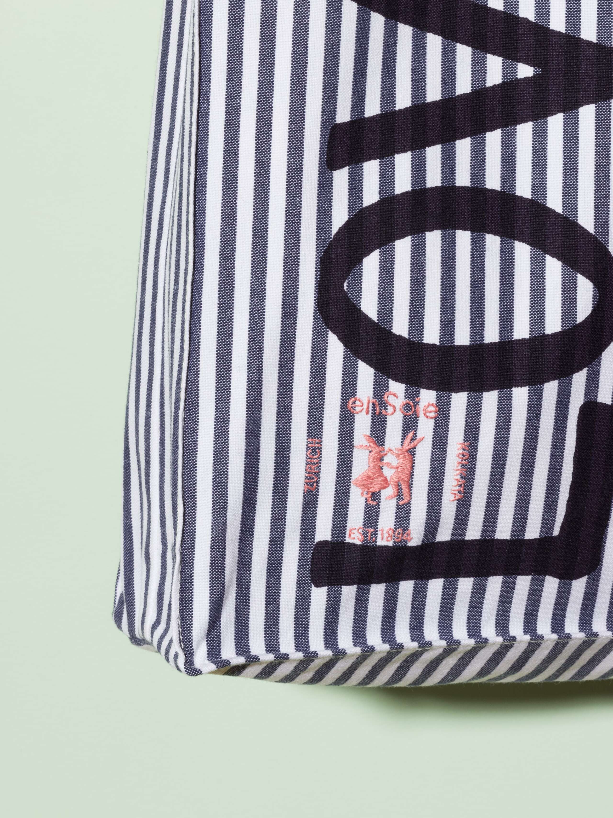  cotton tote bag with a navy stripe pattern and a navy print that says "Love rules forever" and a rabbit ebroidery