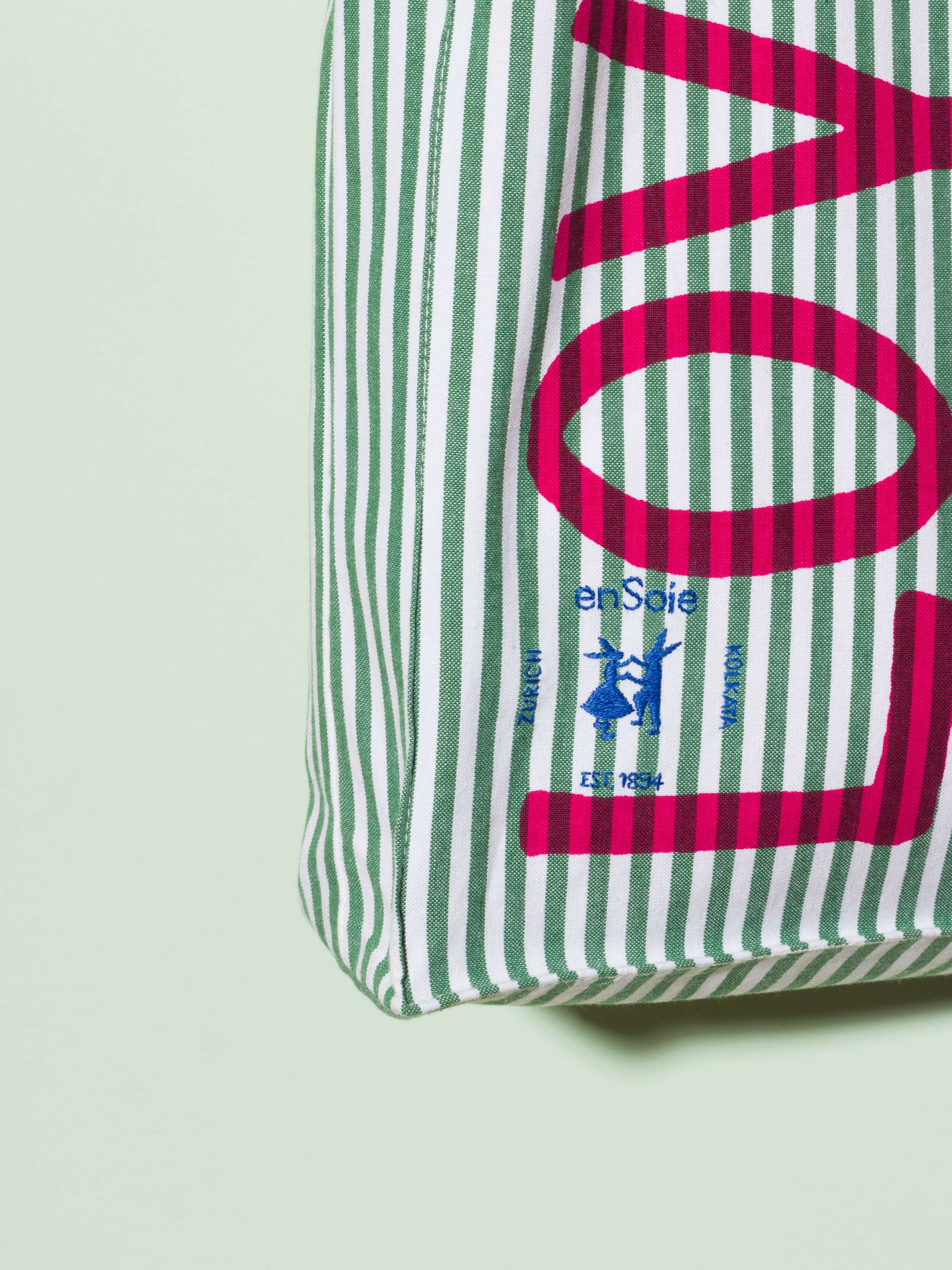  cotton tote bag with a green stripe pattern and a pink print that says "Love rules forever" and a rabbit ebroidery