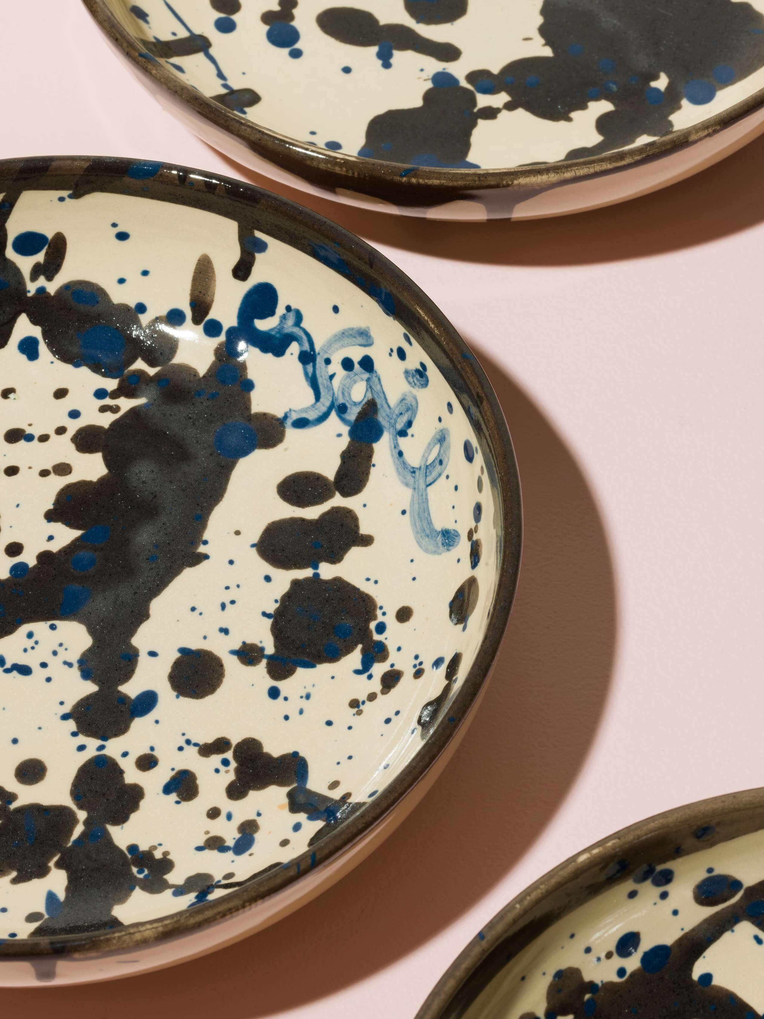 Detail of a hand painted plate with blue an black sprinkles 
