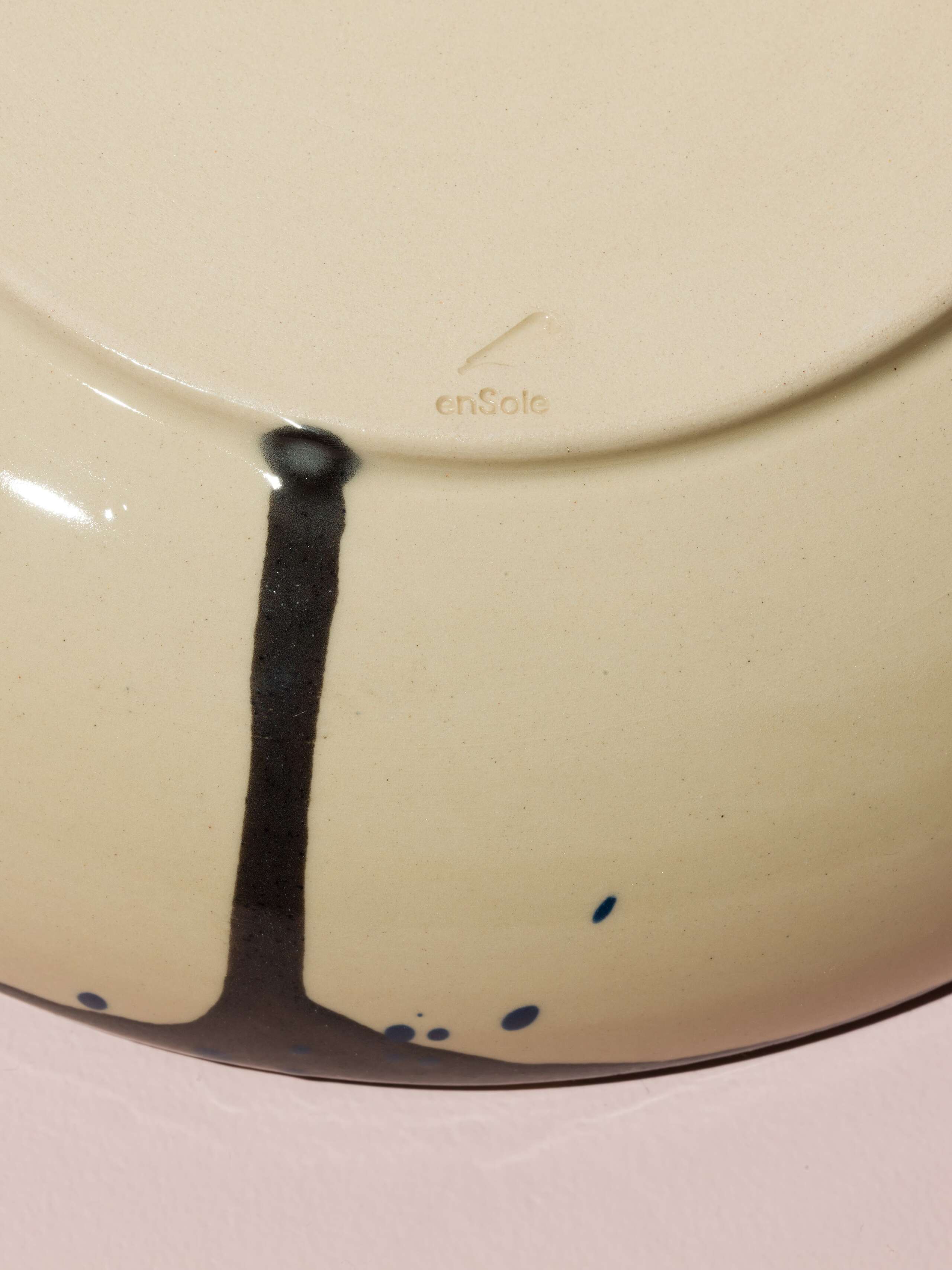 Detail of a hand painted plate with blue an black sprinkles 