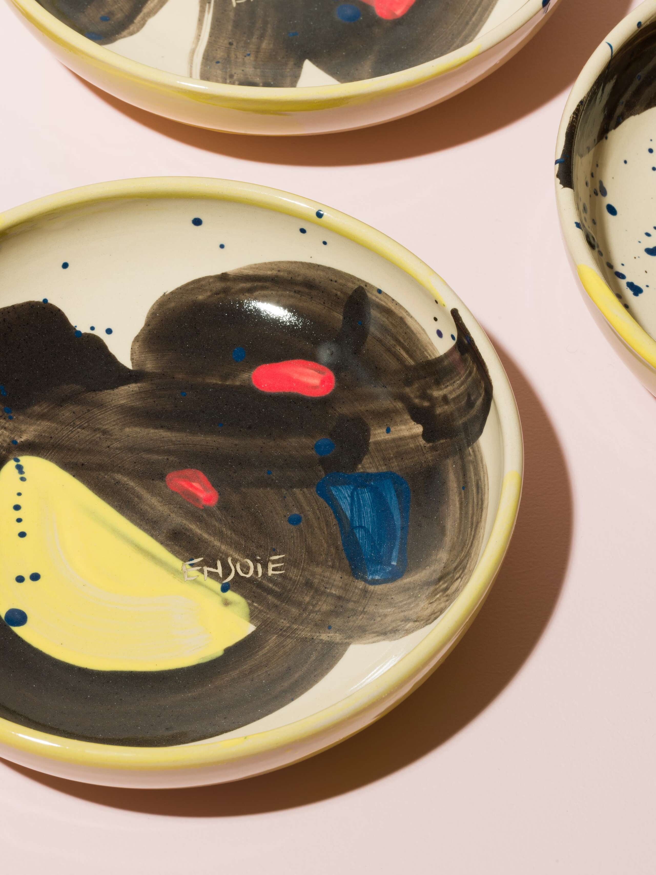Detail of a hand painted plate in beautiful colour shades of blue, yellow, red and black
