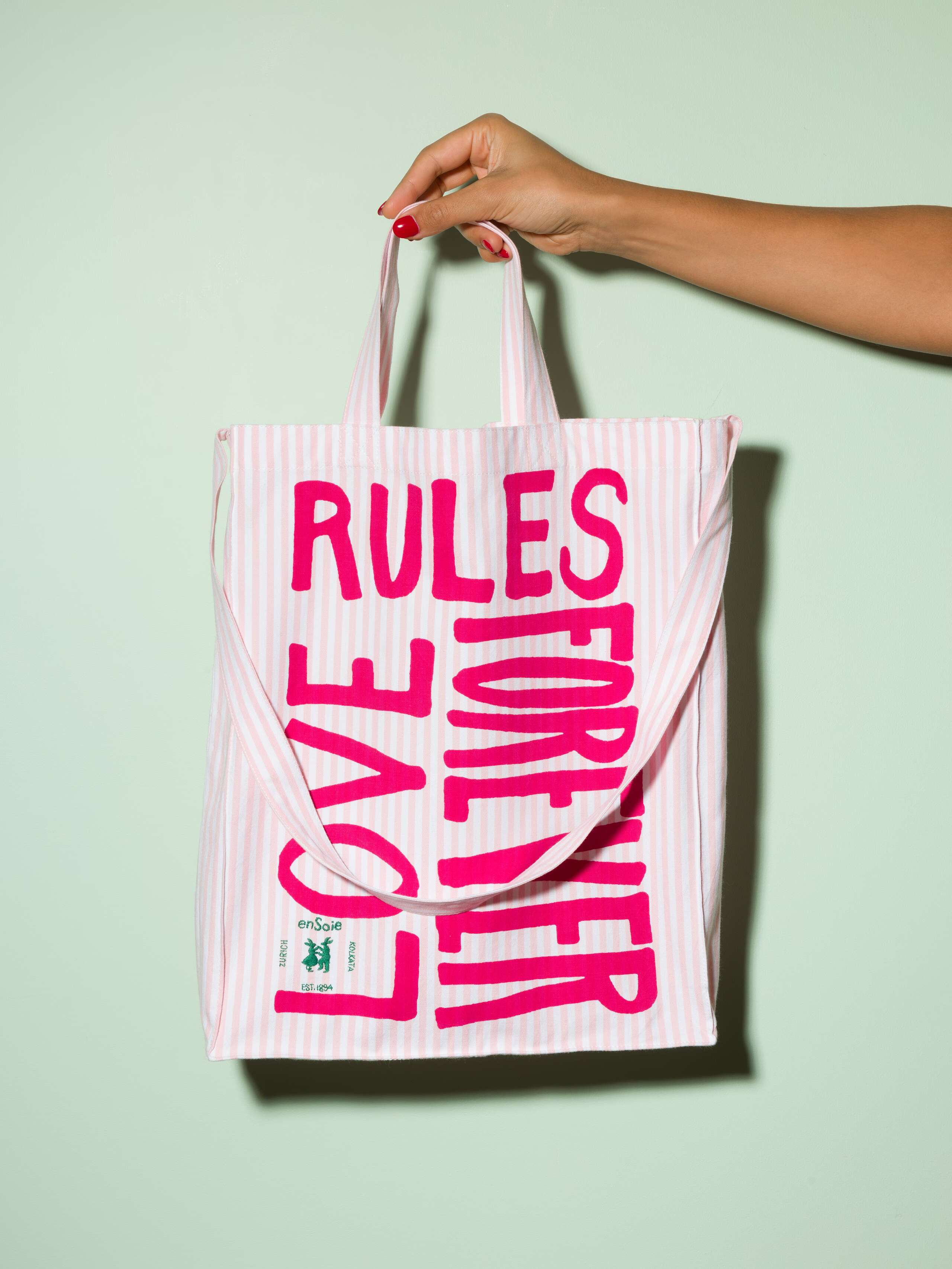  cotton tote bag with a pink stripe pattern and a pink print that says "Love rules forever" and a rabbit ebroidery