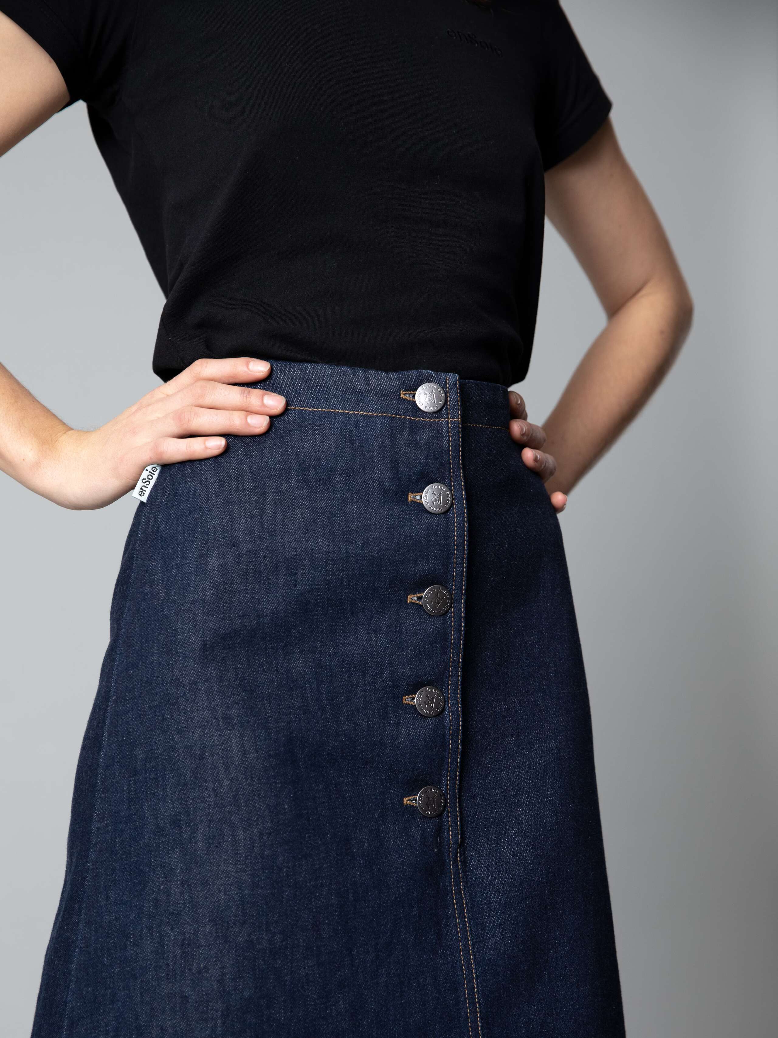 Detail of a denim skirt combined with a black shirt 