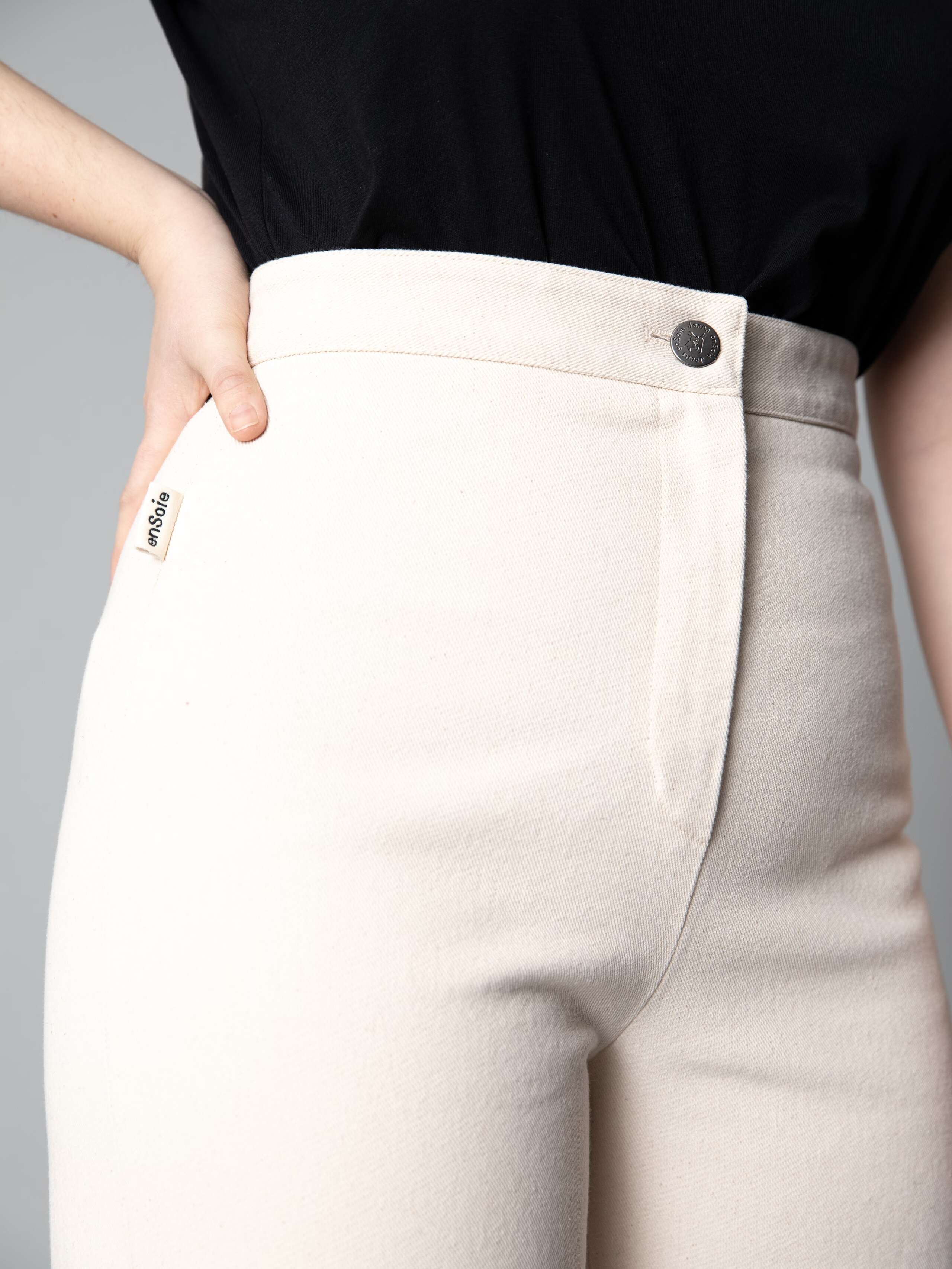 Detail of a beautiful wide leg and high waist jeans in ecru with 