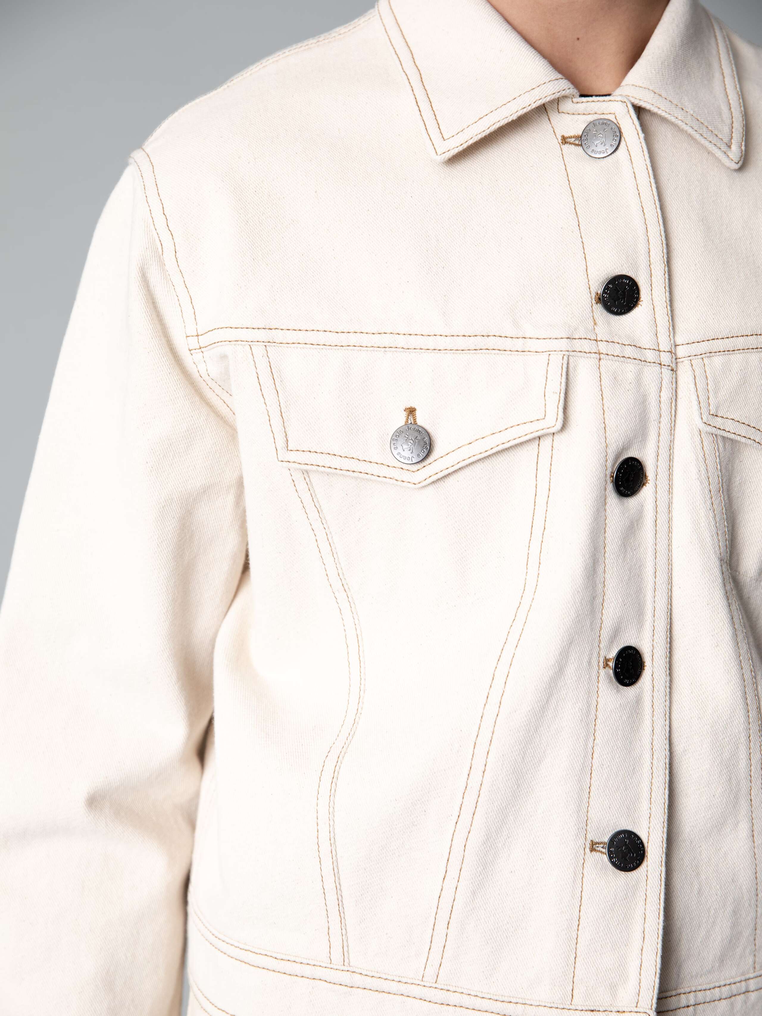 Detail of a boxy denim jacket in a nice ecru colour shade