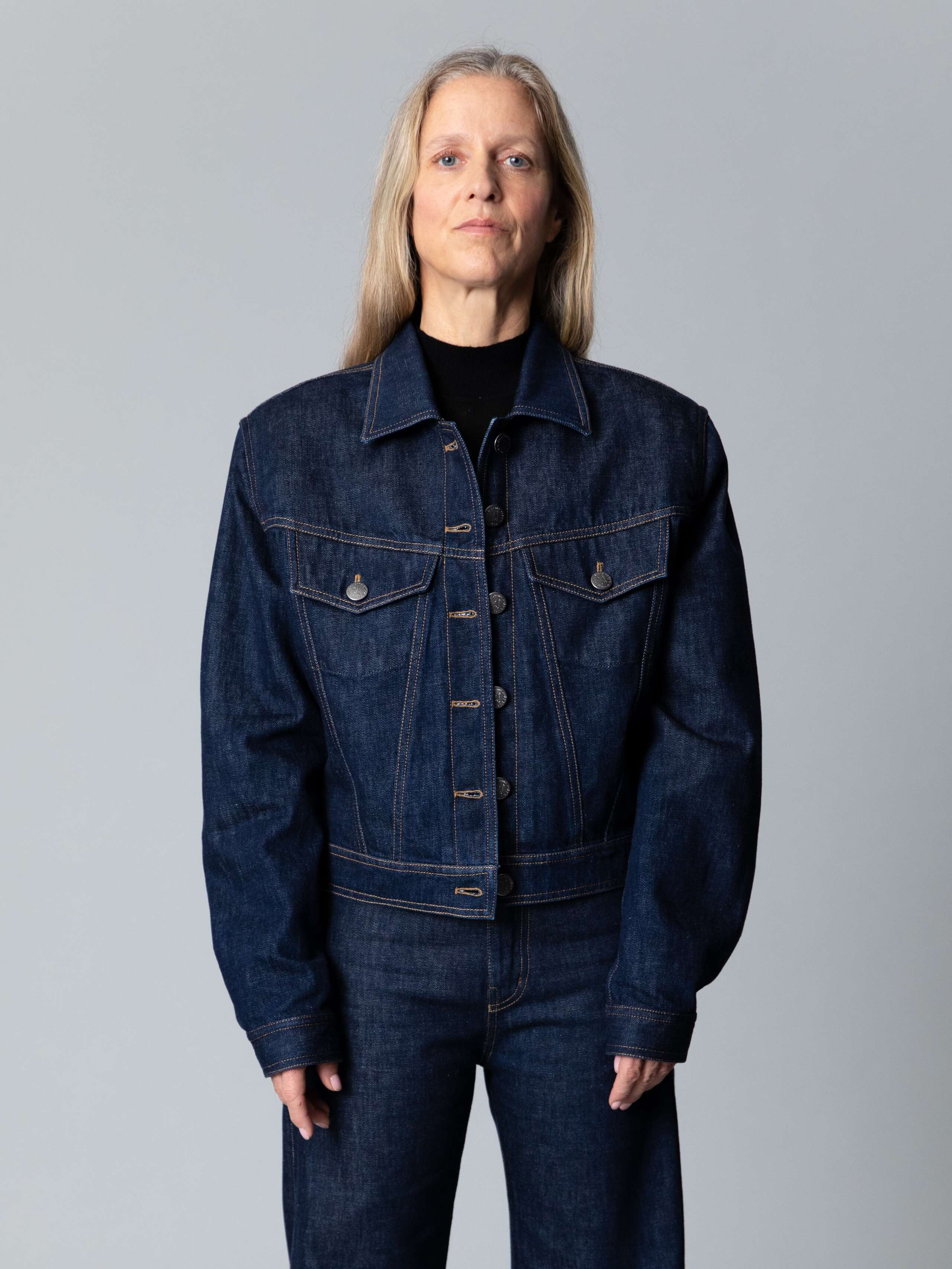 Model is wearing a boxy jeans jacket in classical indigo blue