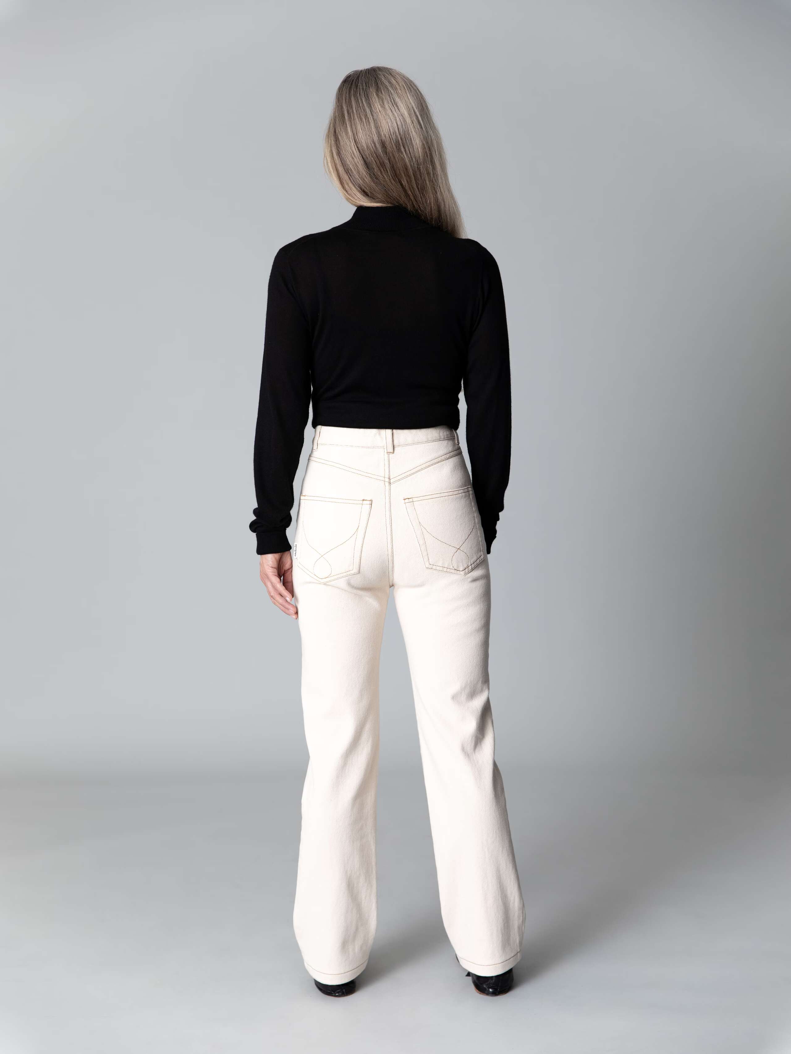 Model is wearing a beautiful high waist jeans in ecru  featuring a straight cut 