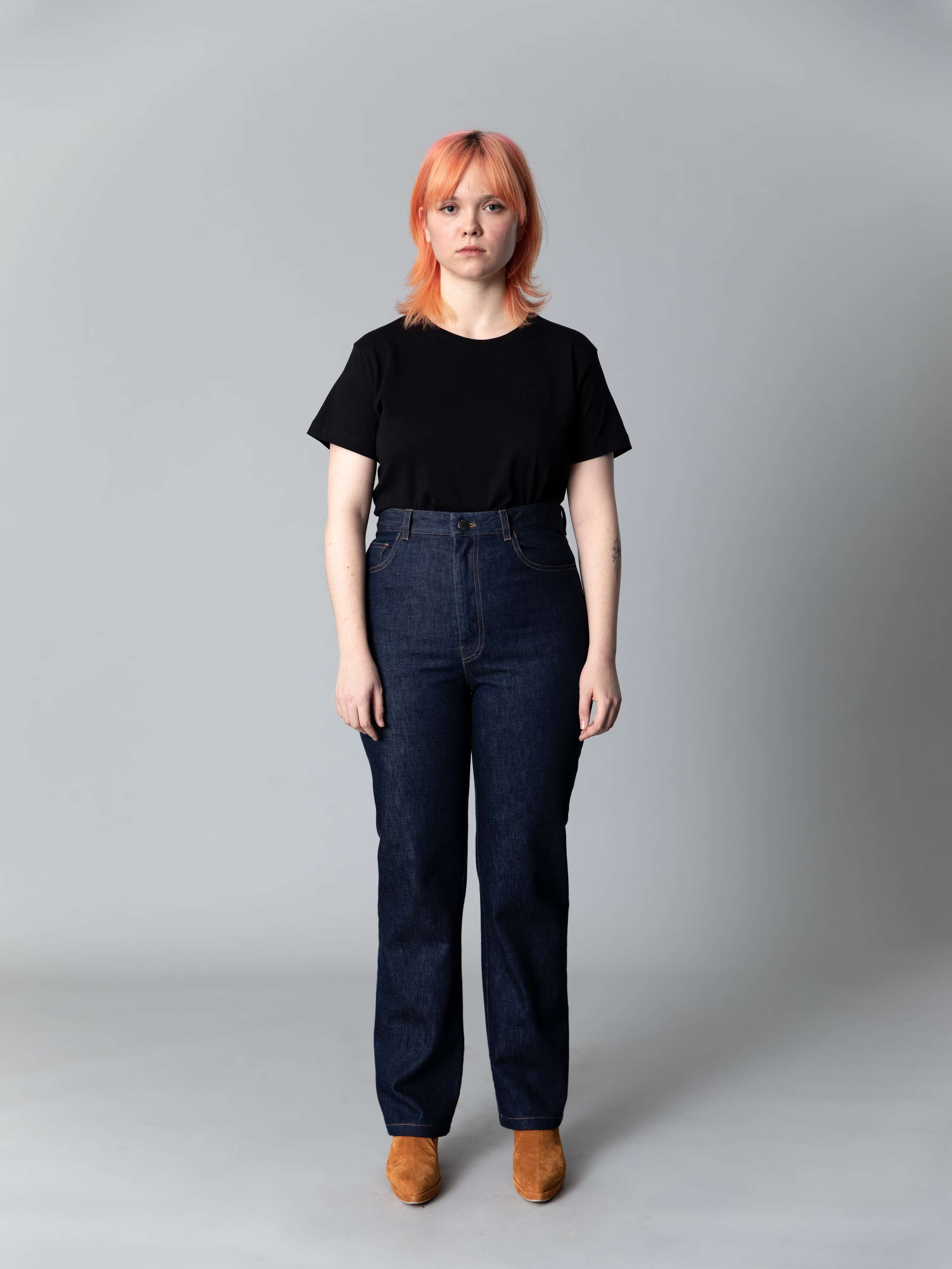 Model wears a beautiful straight leg high waist jeans in indigo blue