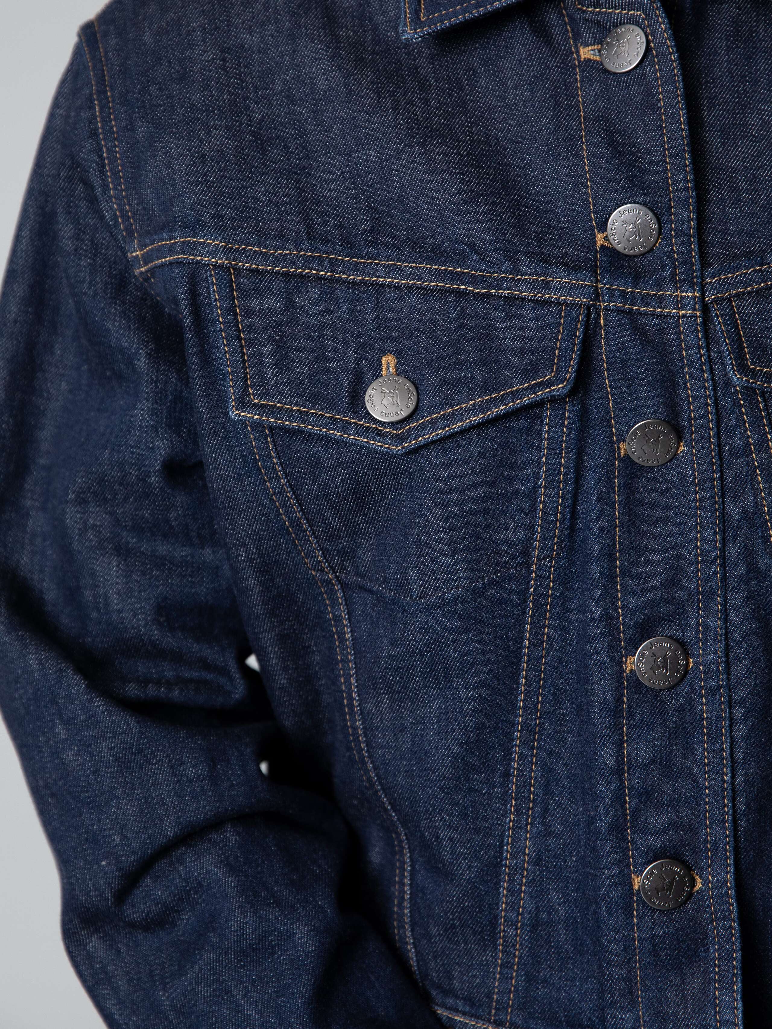 Details of a boxy denim jacket in dark indigo 