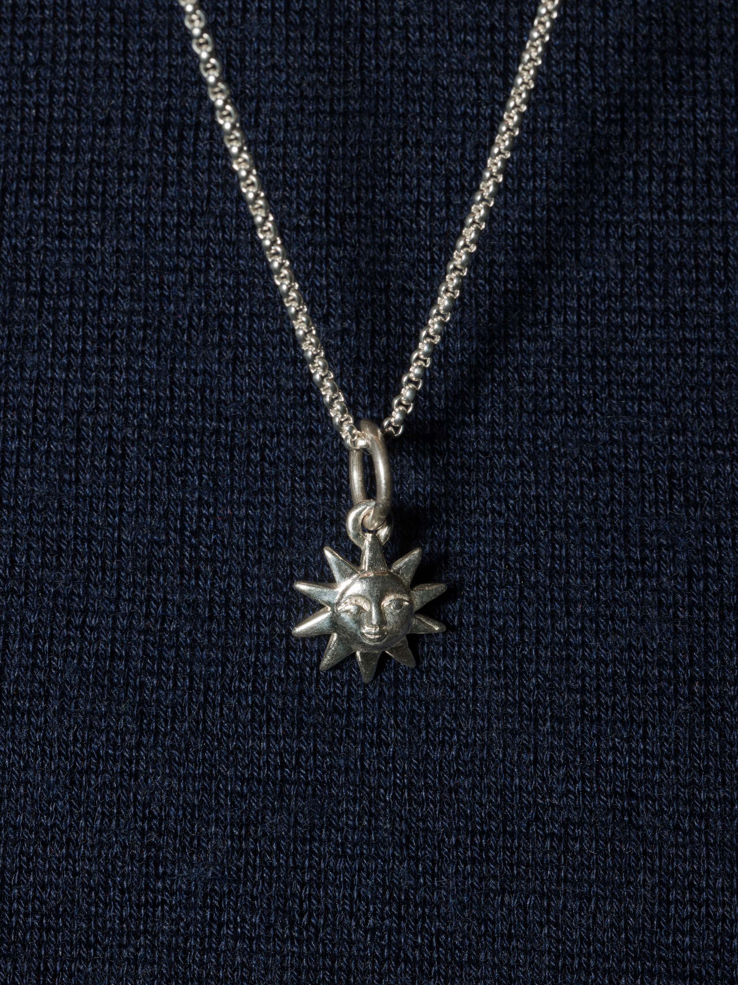 Picture of a beautiful sun silver pendant with a very detail rich face