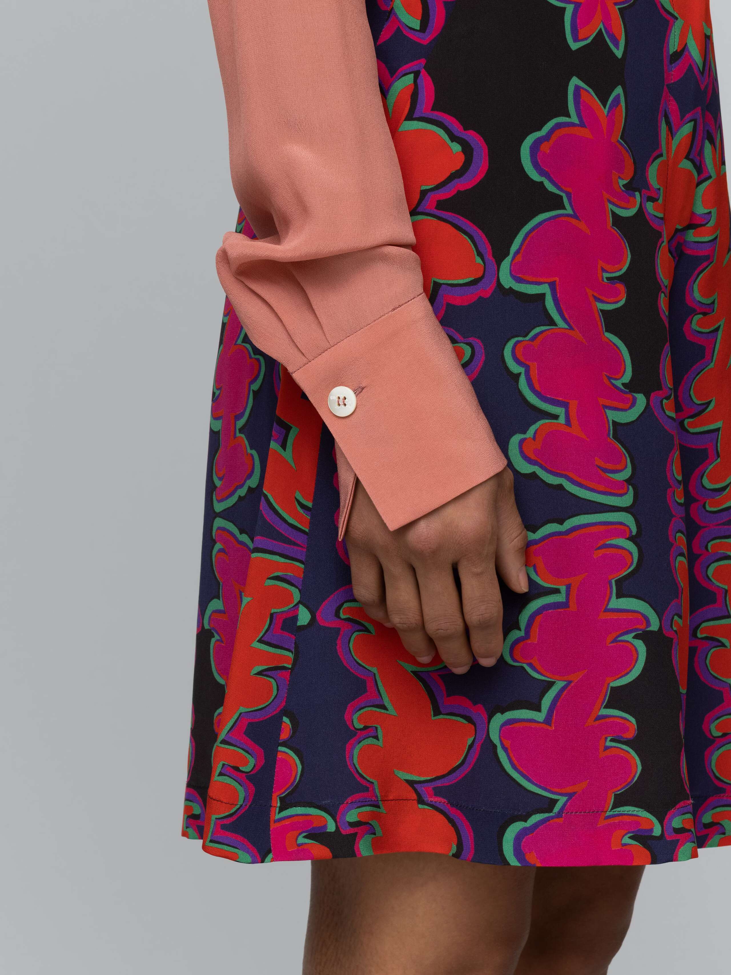 Detail of a long terracotta coloured silk blouse 