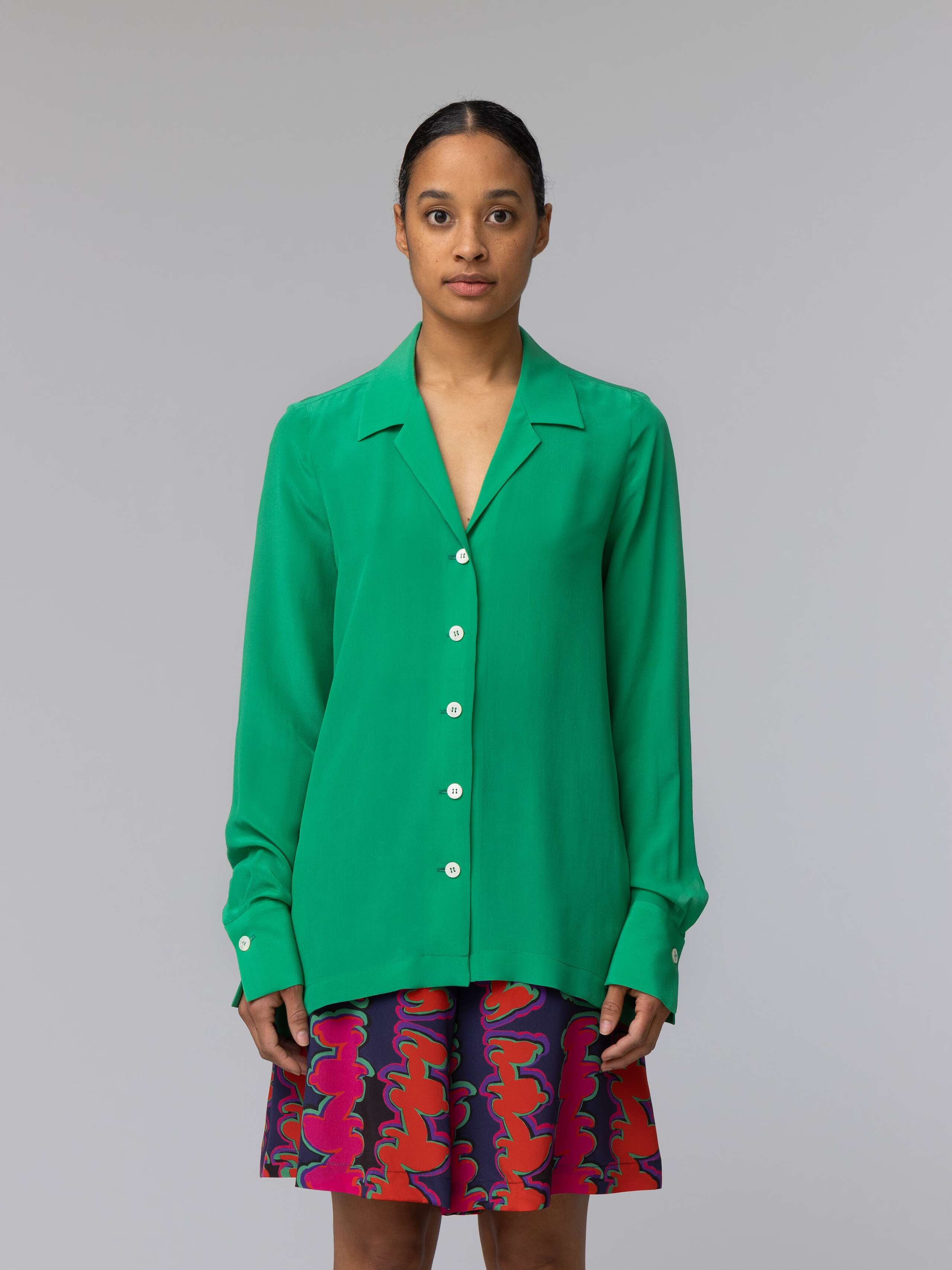 Model wears a bright green silk blouse 