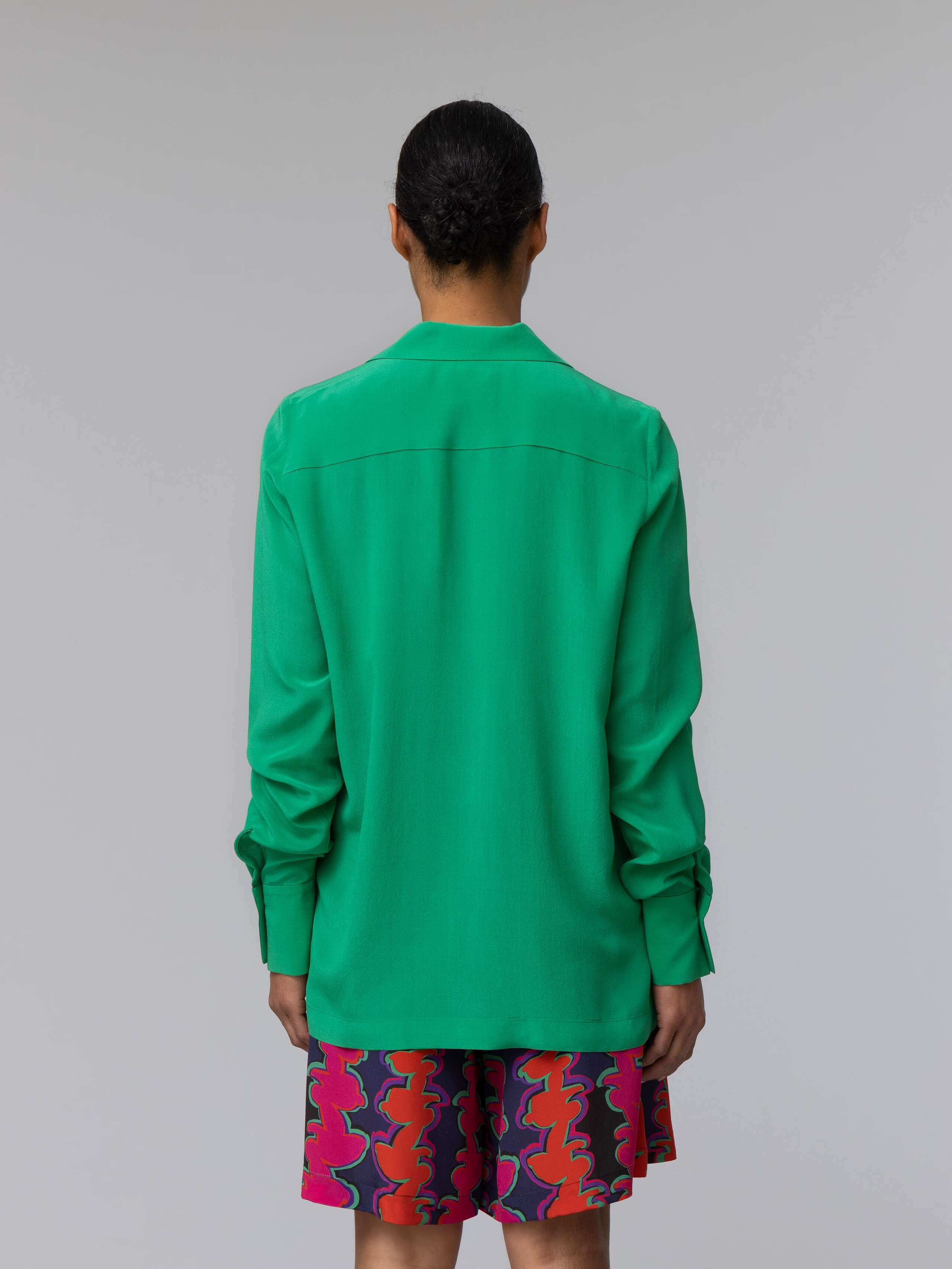 Model wears a bright green silk blouse 