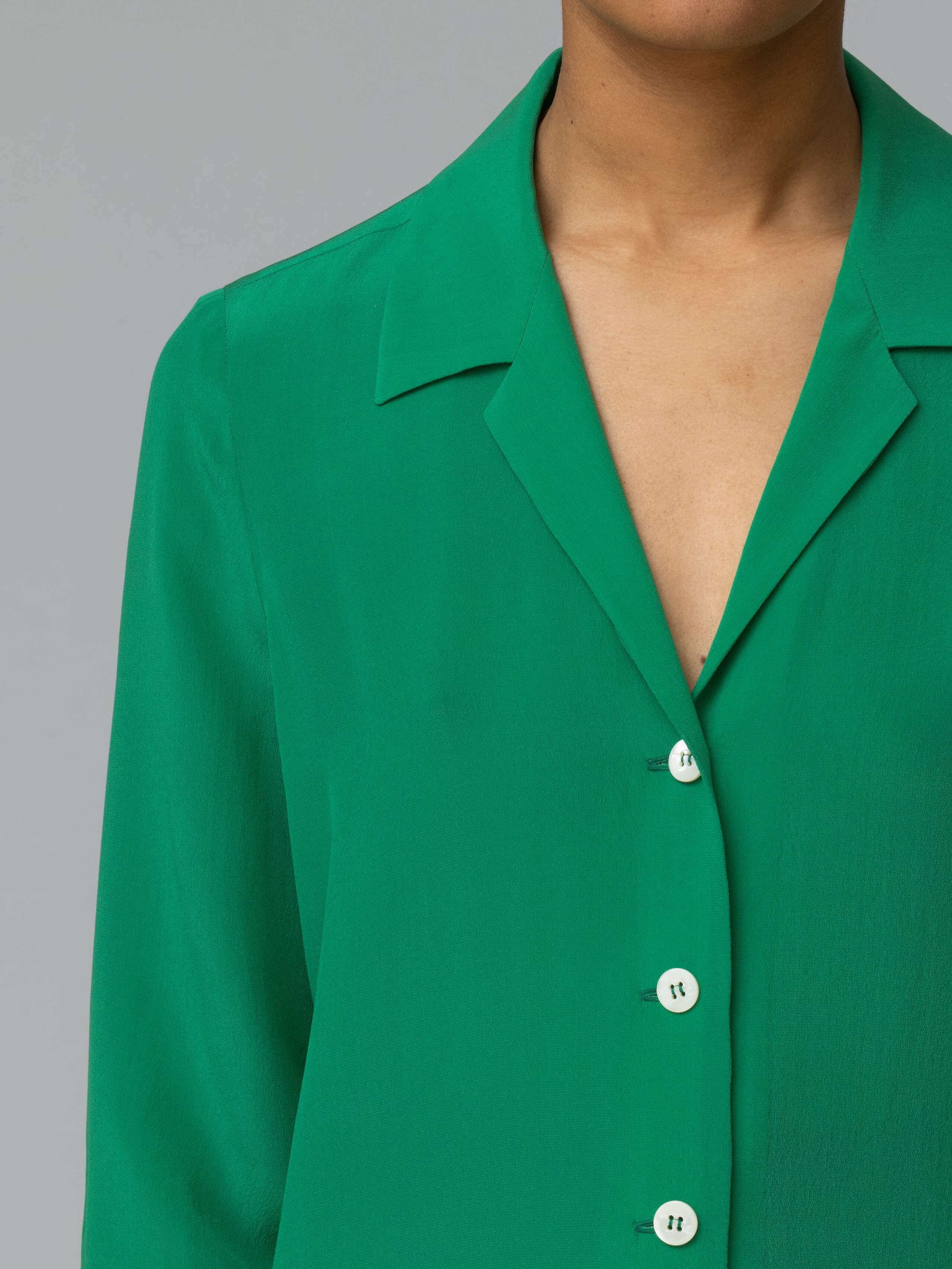 Detail of a bright green silk blouse 