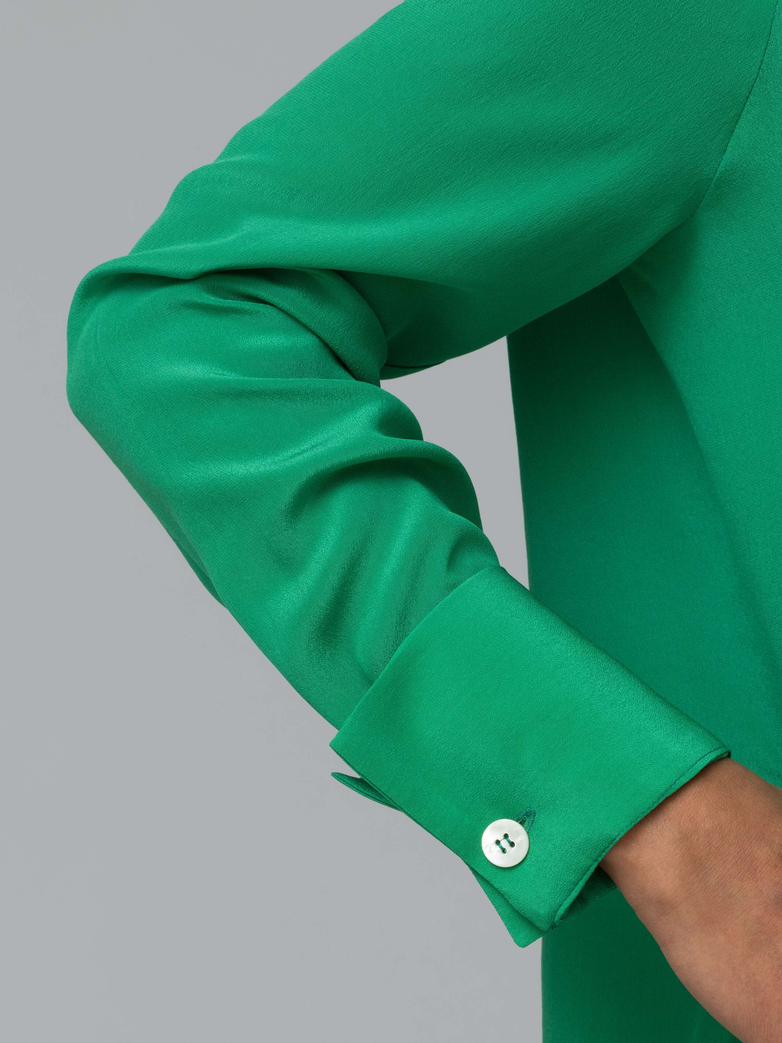 Detail of a bright green silk blouse 
