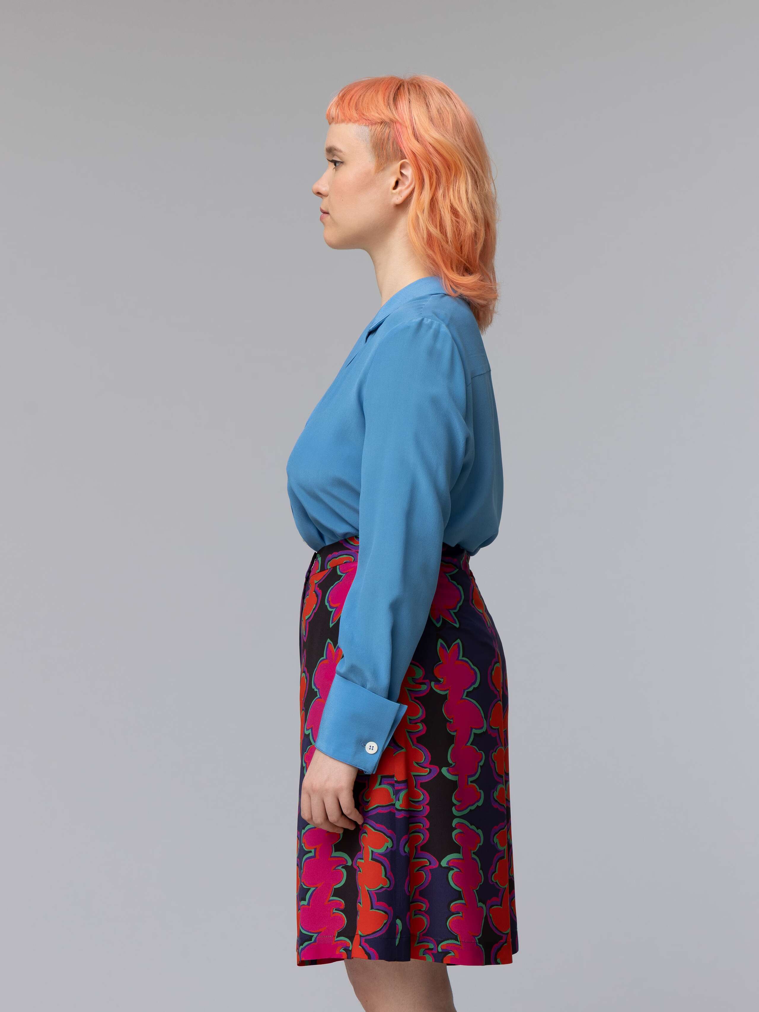 Model wears a blue silk blouse combined with wide summery shorts