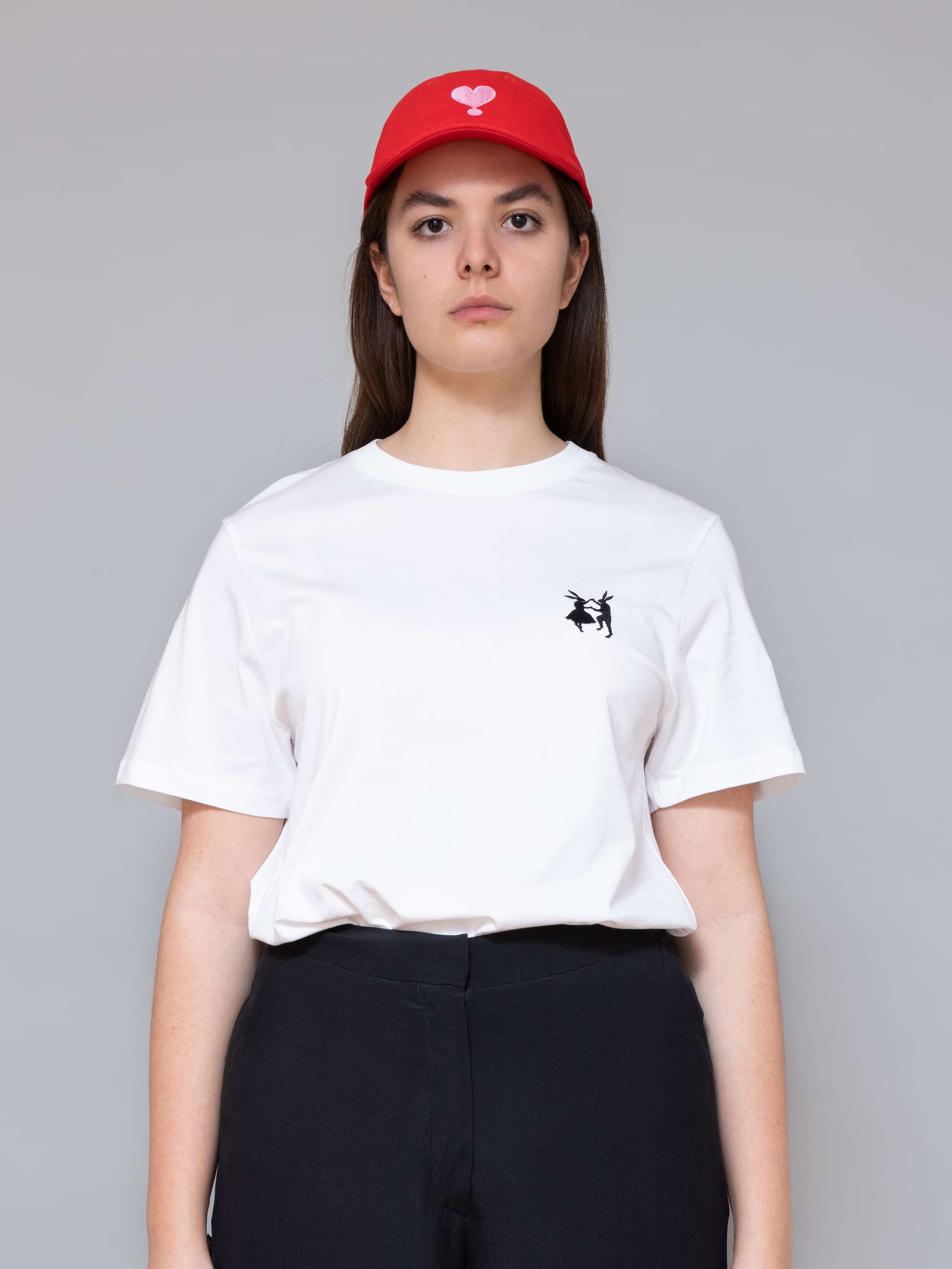 Picture of a femal model wearing a red base cap with pink heart embroidery