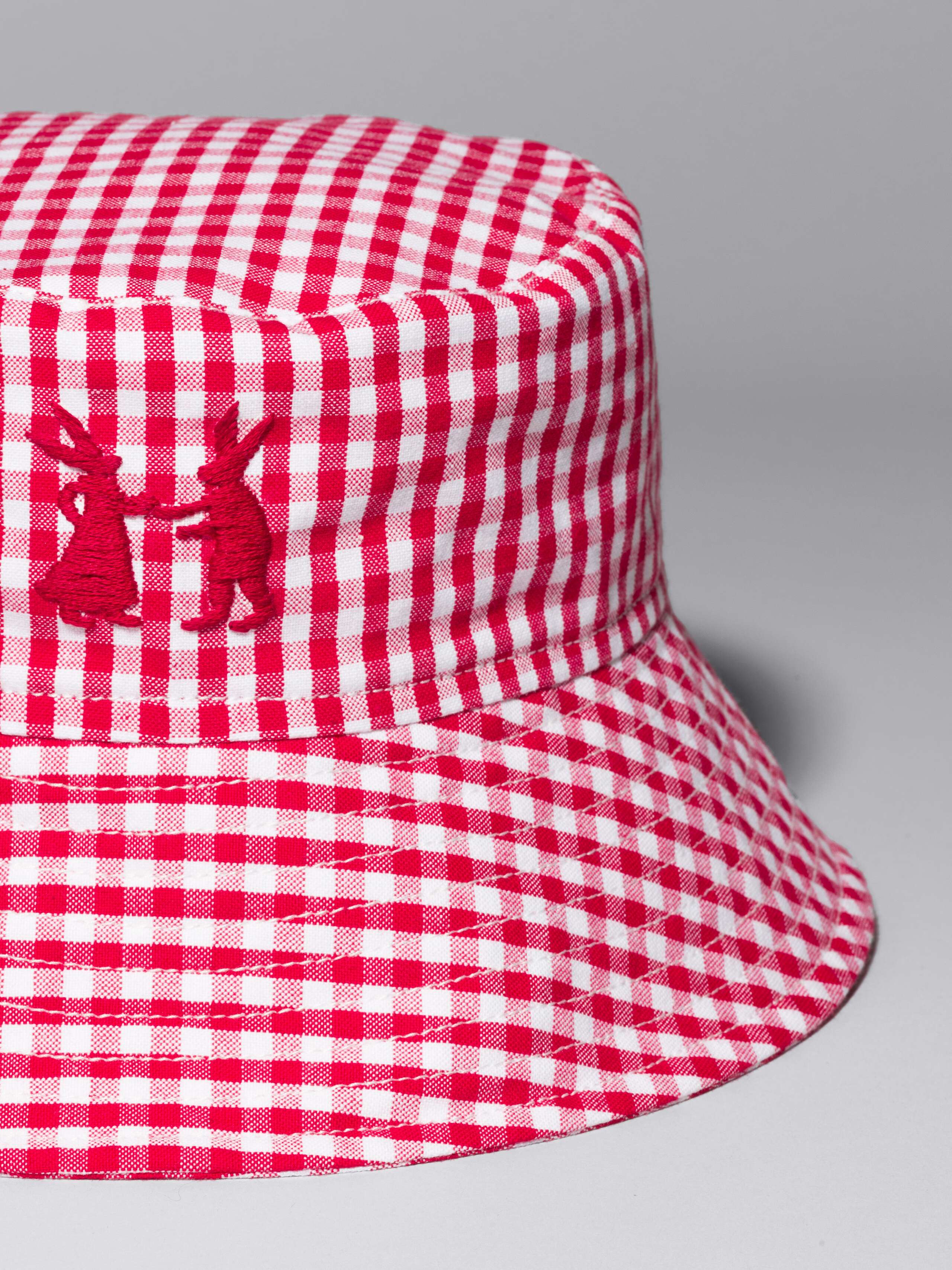 Picture of a bucket hat made of cotton featuring a beautiful red vichy check pattern and rabbit embroidery