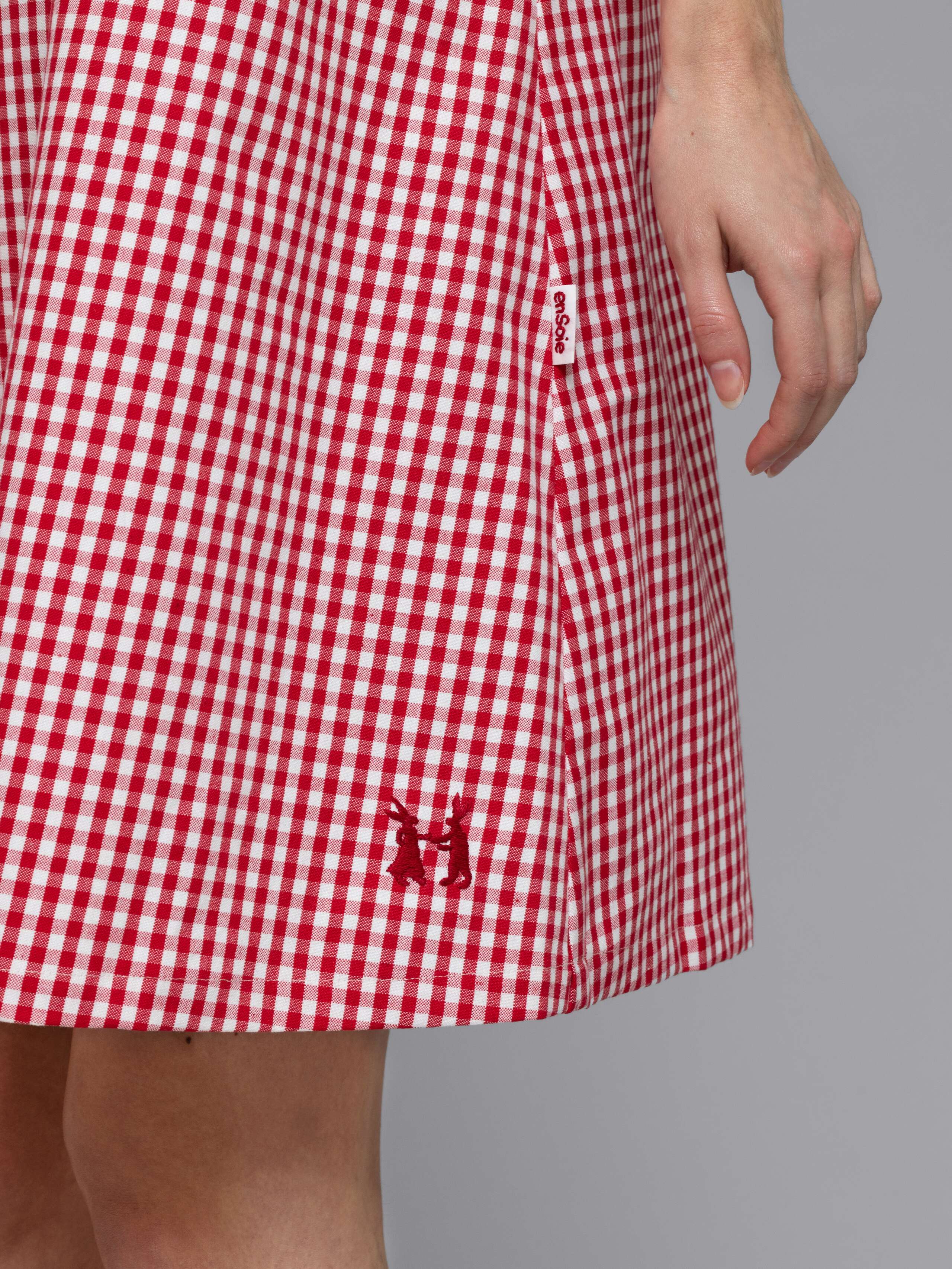 Female model is wearing an airy cotton dress featuring a red vichy check pattern