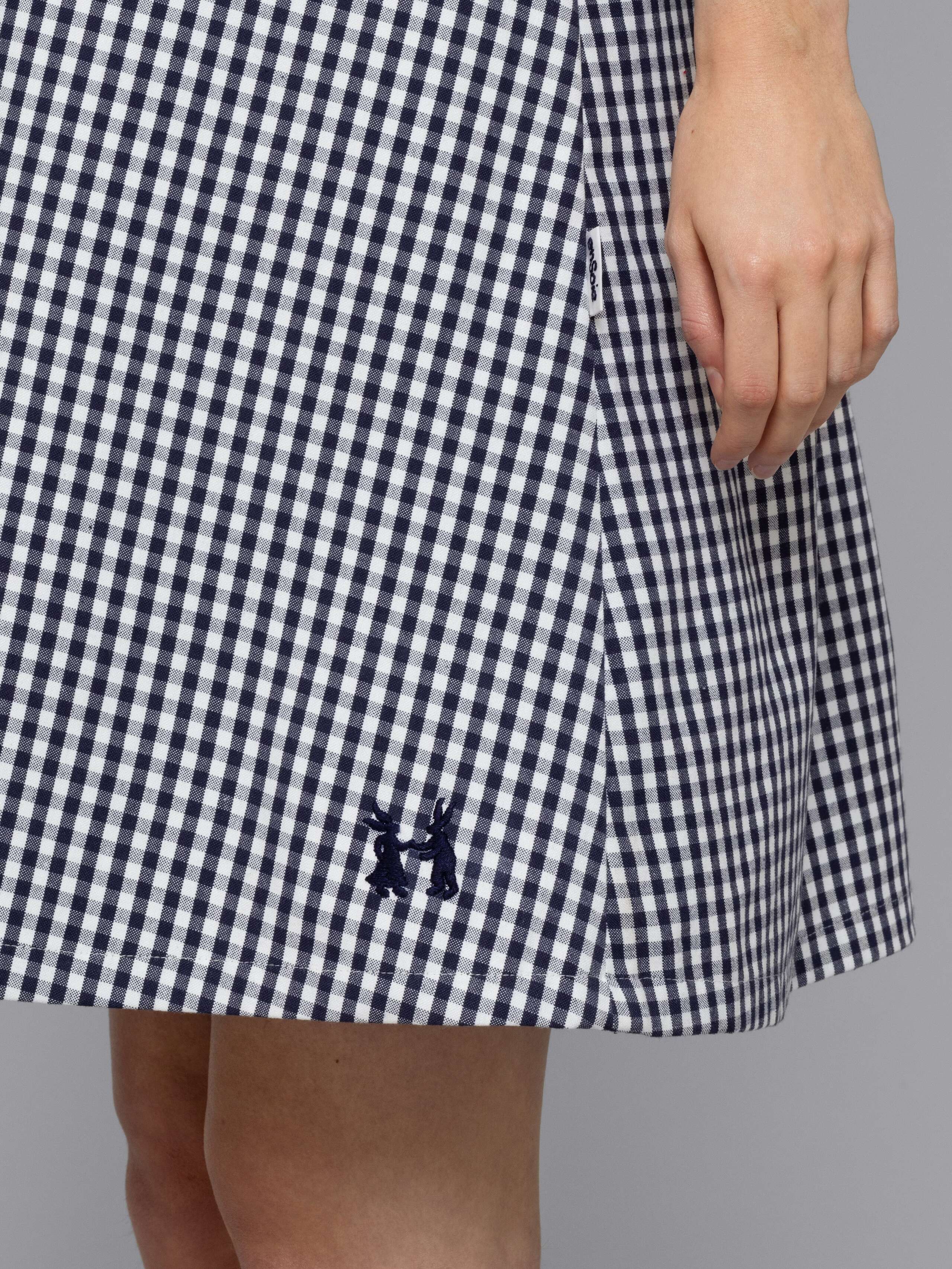Female model is wearing an airy cotton dress featuring a navy vichy check pattern