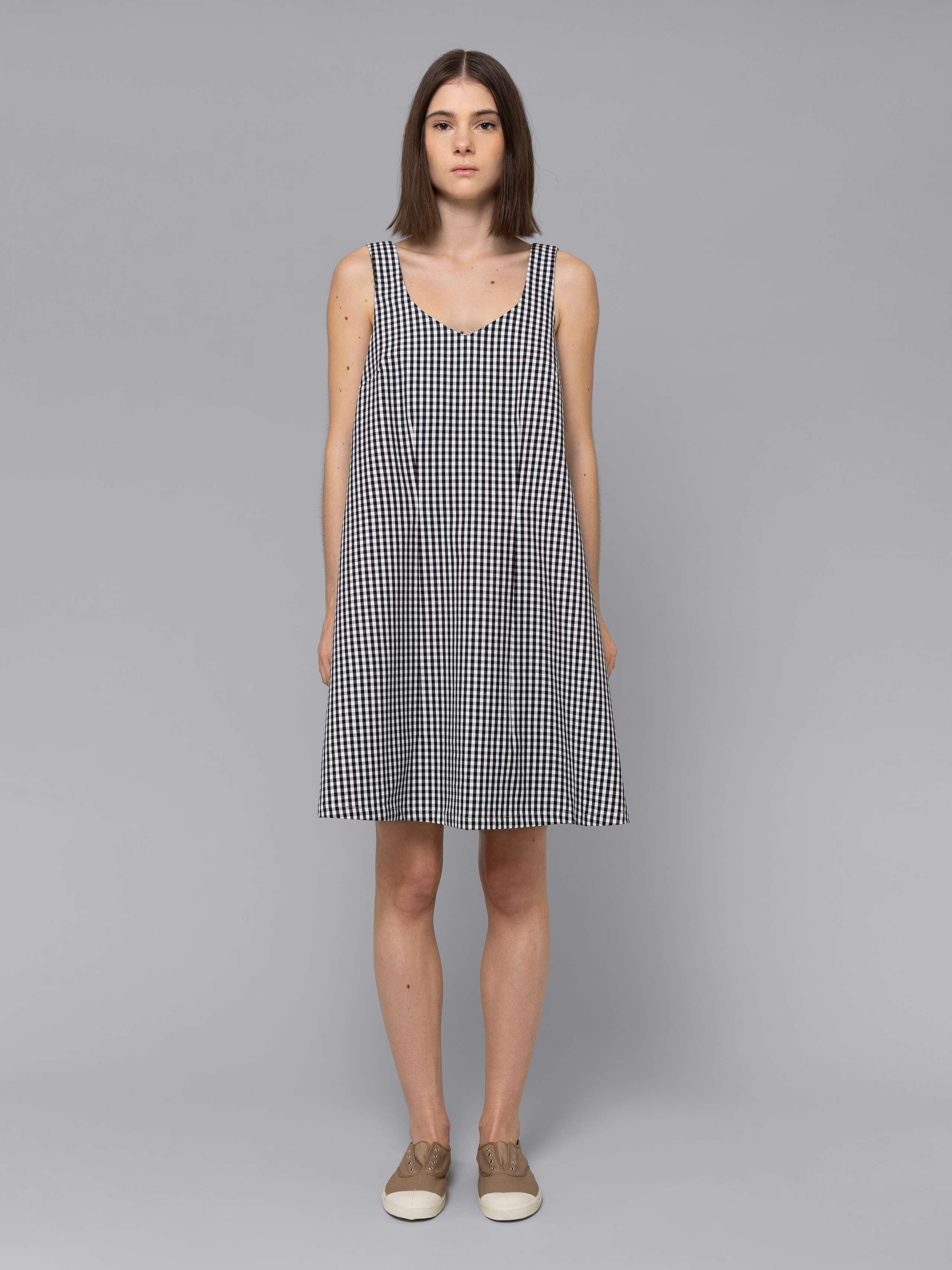 Female model is wearing an airy cotton dress featuring a black vichy check pattern