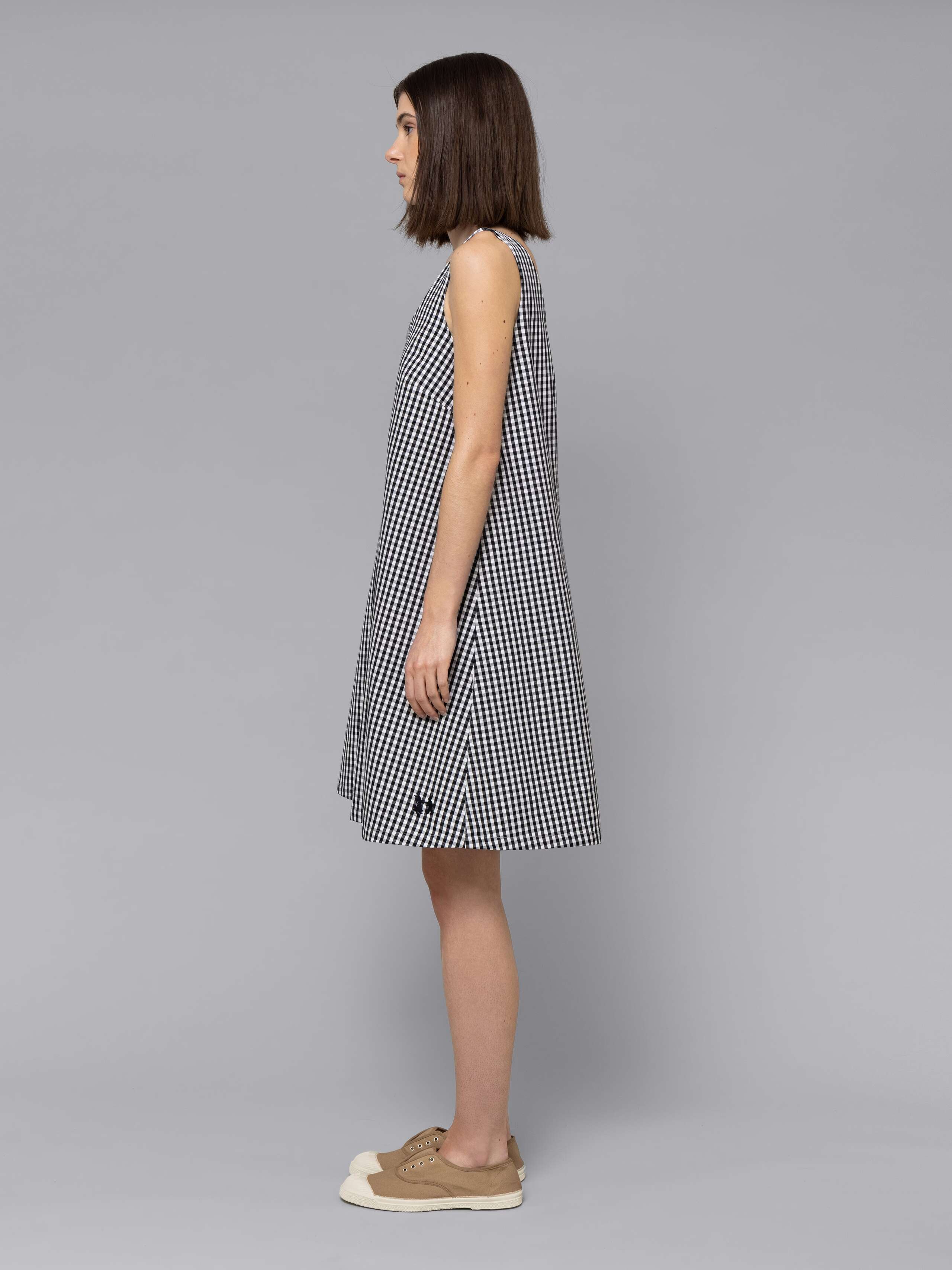 Female model is wearing an airy cotton dress featuring a black vichy check pattern