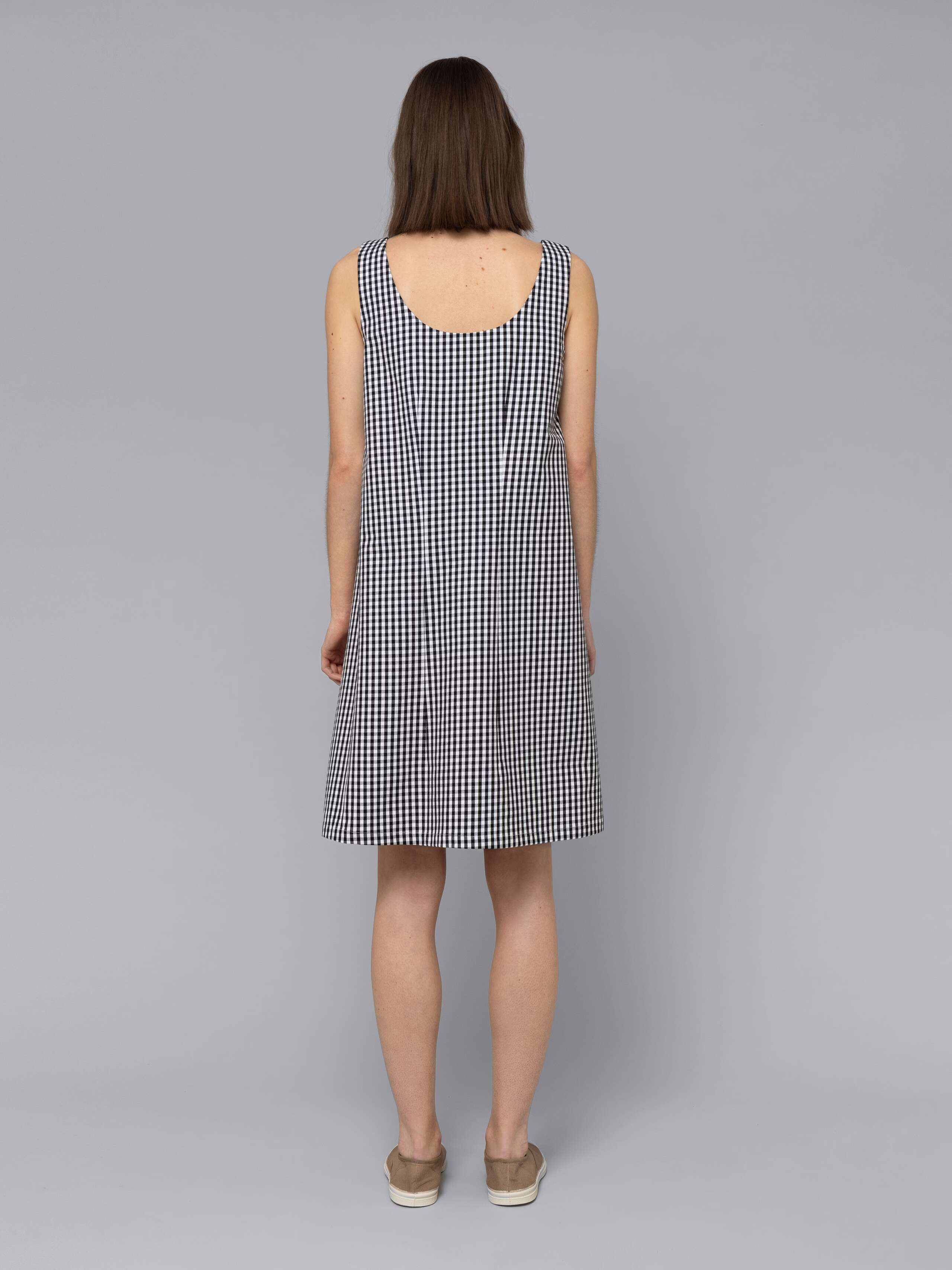 Female model is wearing an airy cotton dress featuring a black vichy check pattern