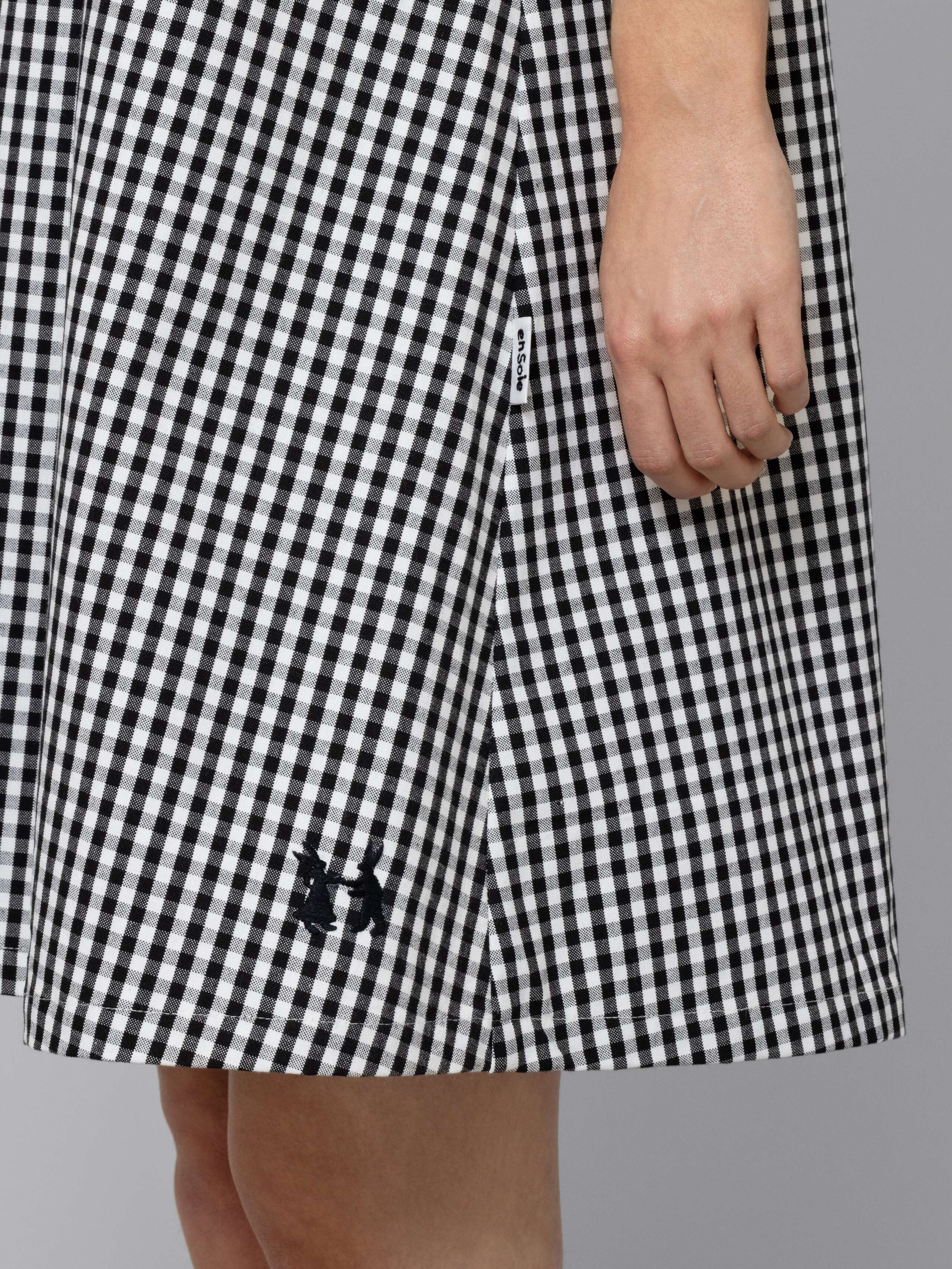 Female model is wearing an airy cotton dress featuring a black vichy check pattern