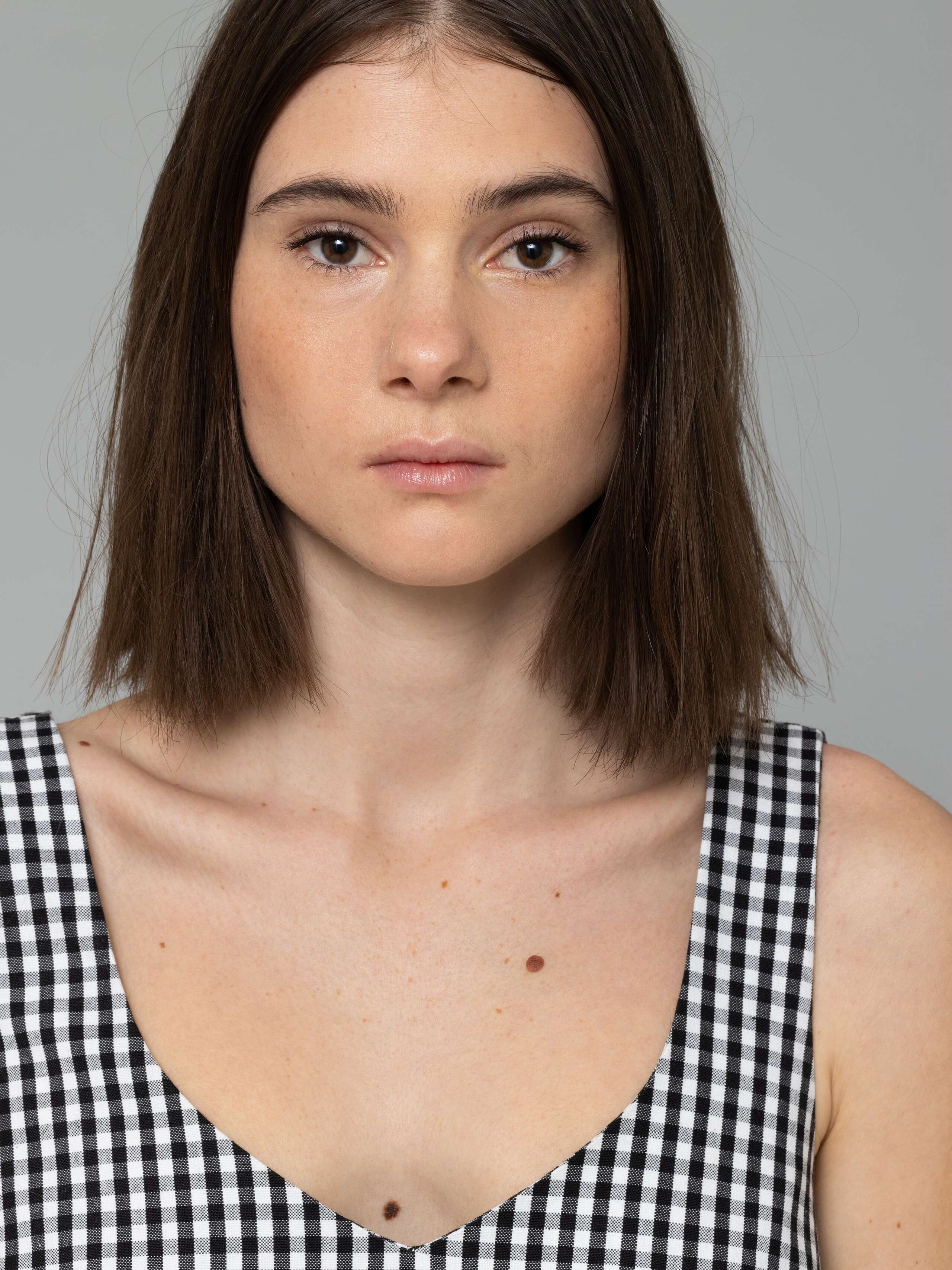 Female model is wearing an airy cotton dress featuring a black vichy check pattern