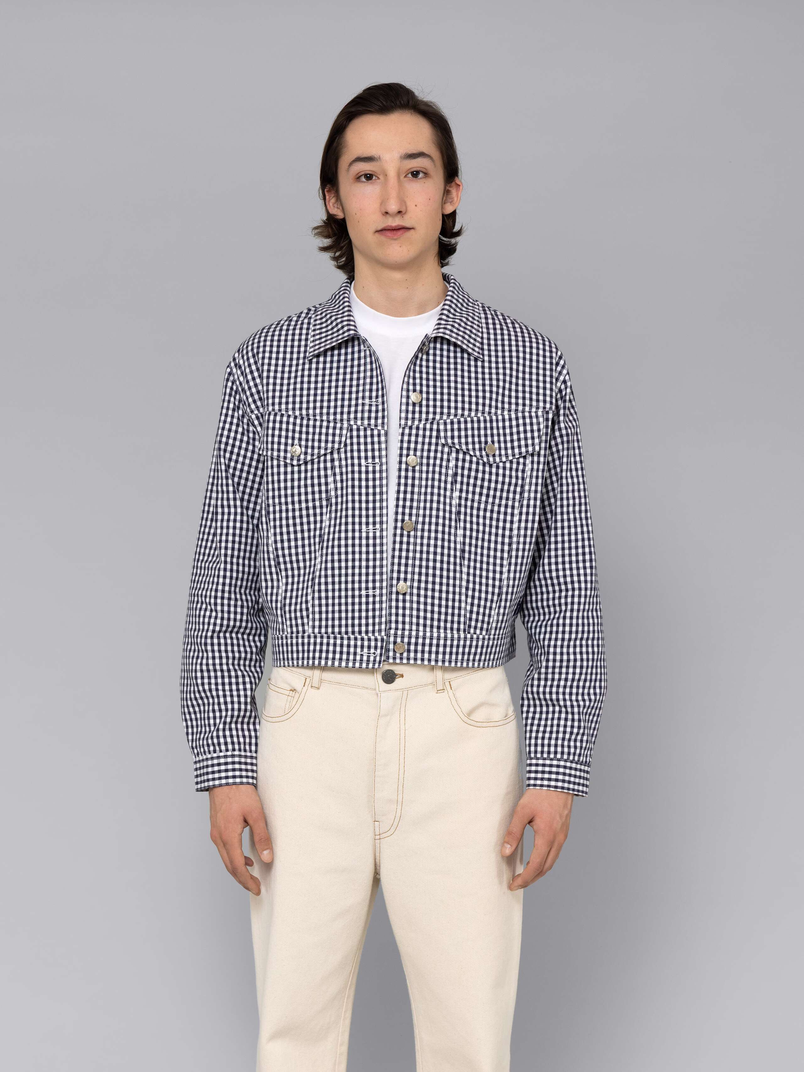 Male model is wearing a beautiful denim jacket featuring a beautiful navy vichy check pattern