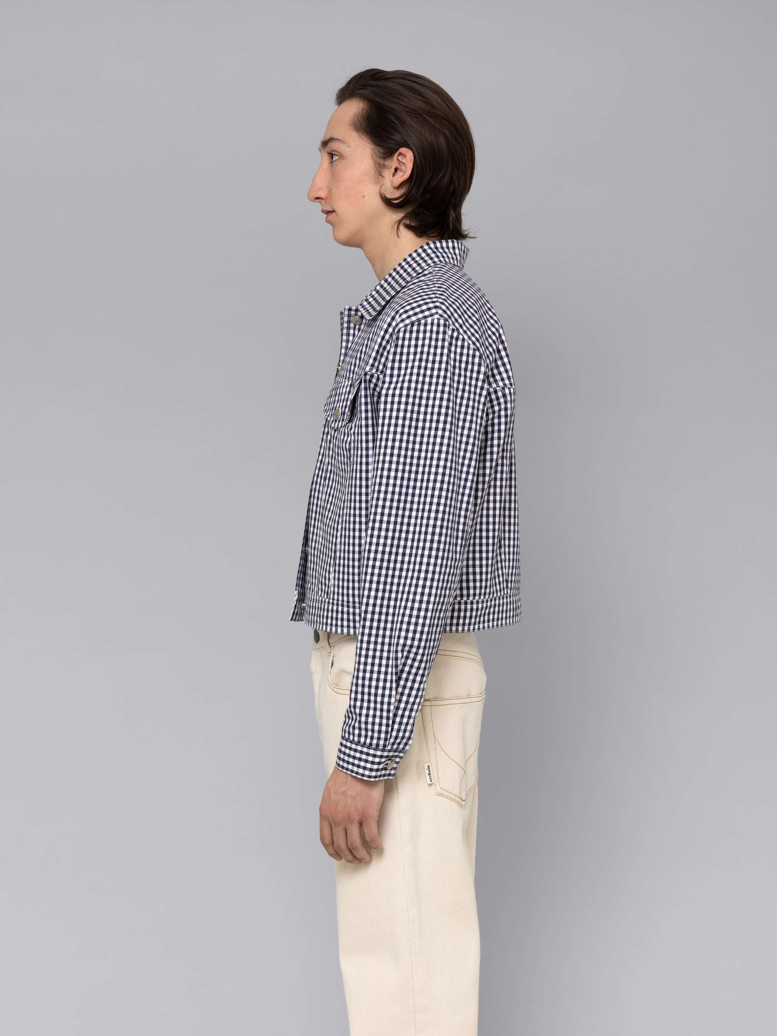 Male model is wearing a beautiful denim jacket featuring a beautiful navy vichy check pattern