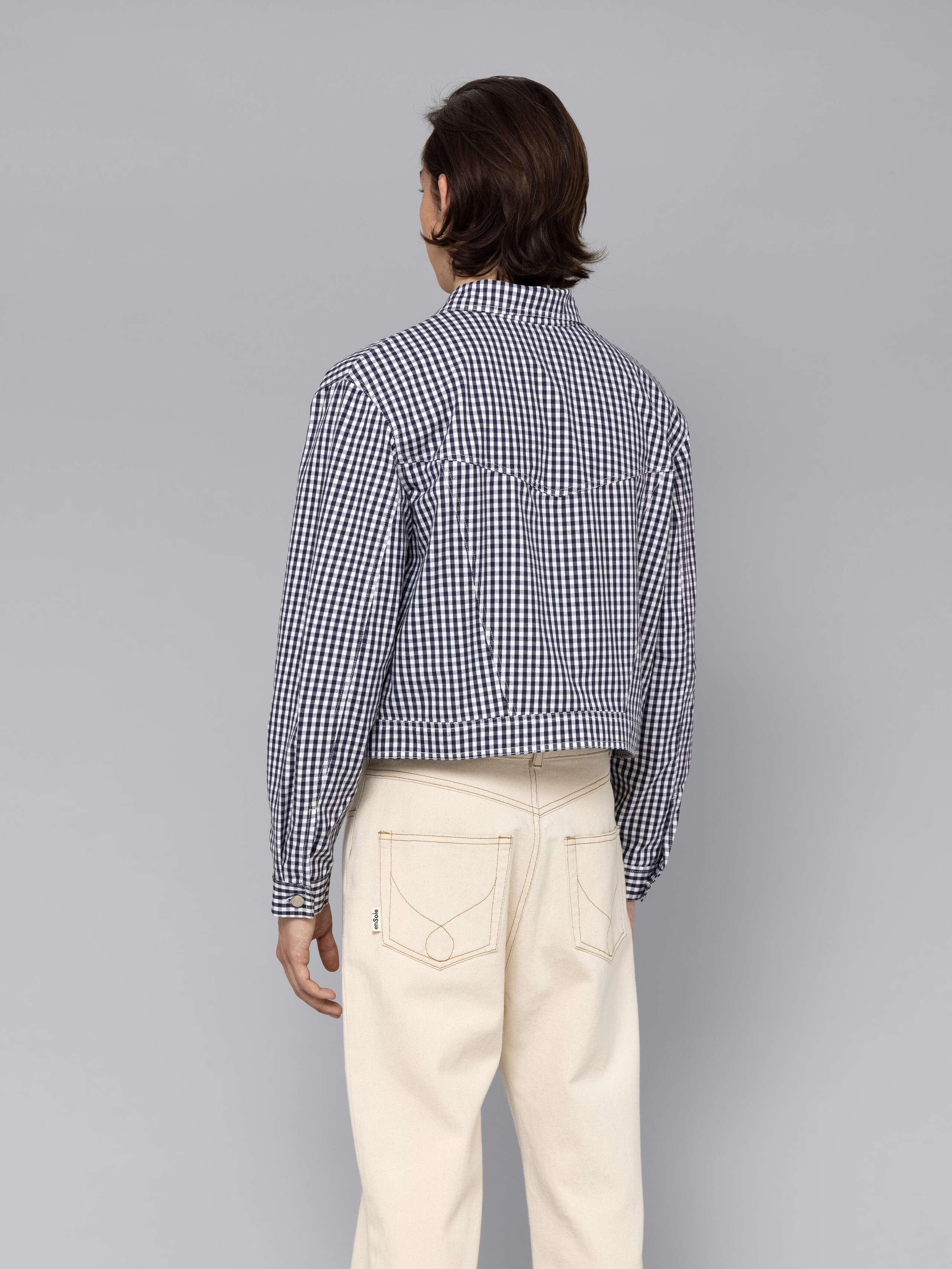 Male model is wearing a beautiful denim jacket featuring a beautiful navy vichy check pattern