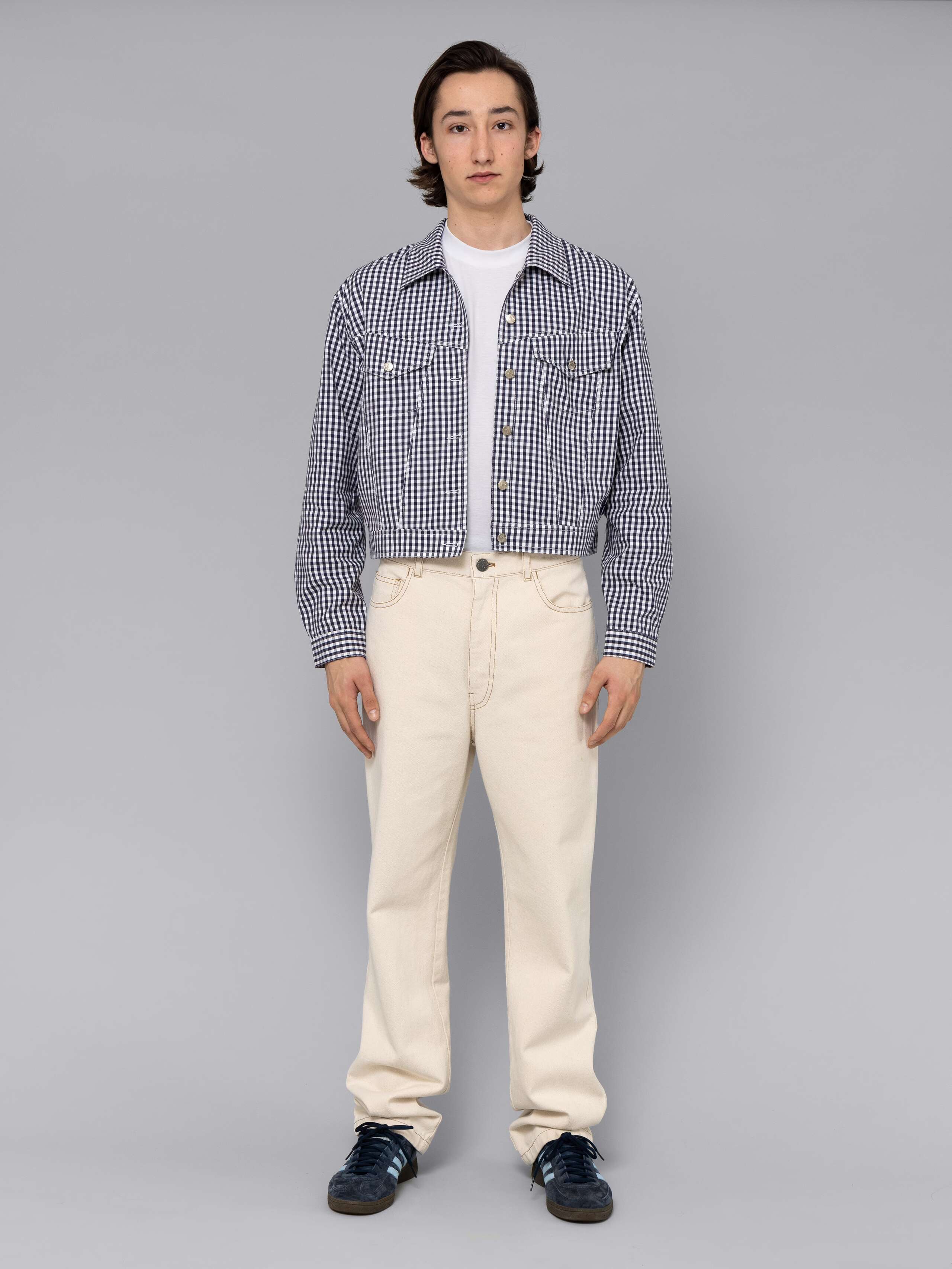 Male model is wearing a beautiful denim jacket featuring a beautiful navy vichy check pattern