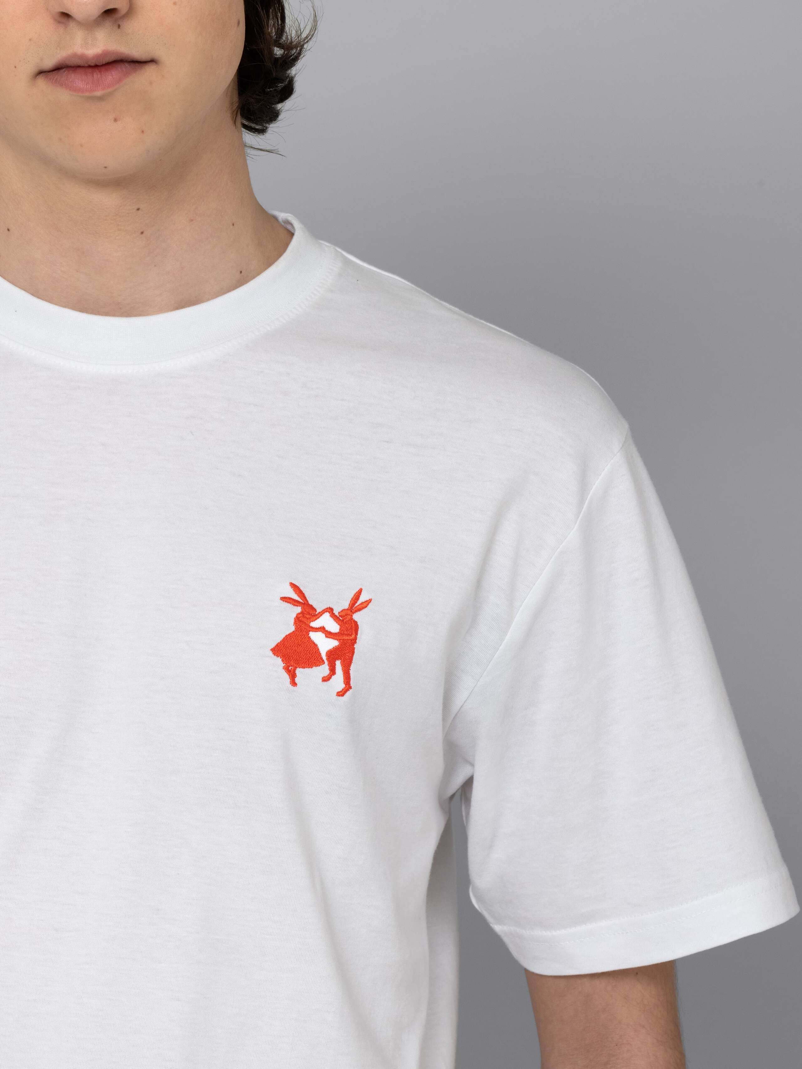 Male model is wearing a white t-shirt with a orange red rabbit embroidery