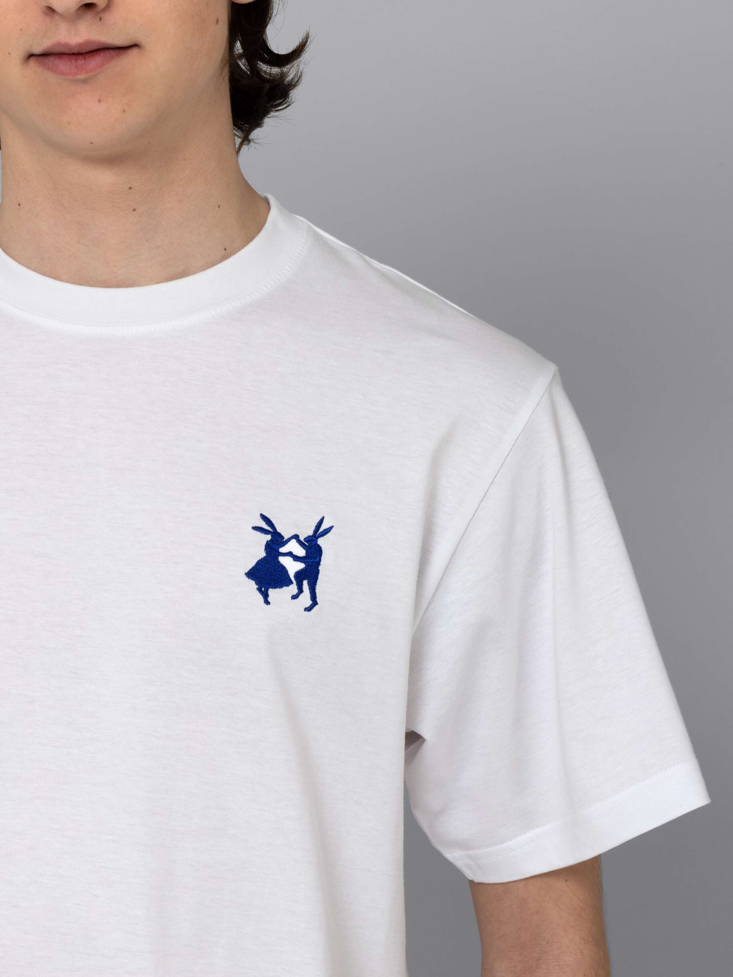 Male model is wearing a white t-shirt with a blue rabbit embroidery