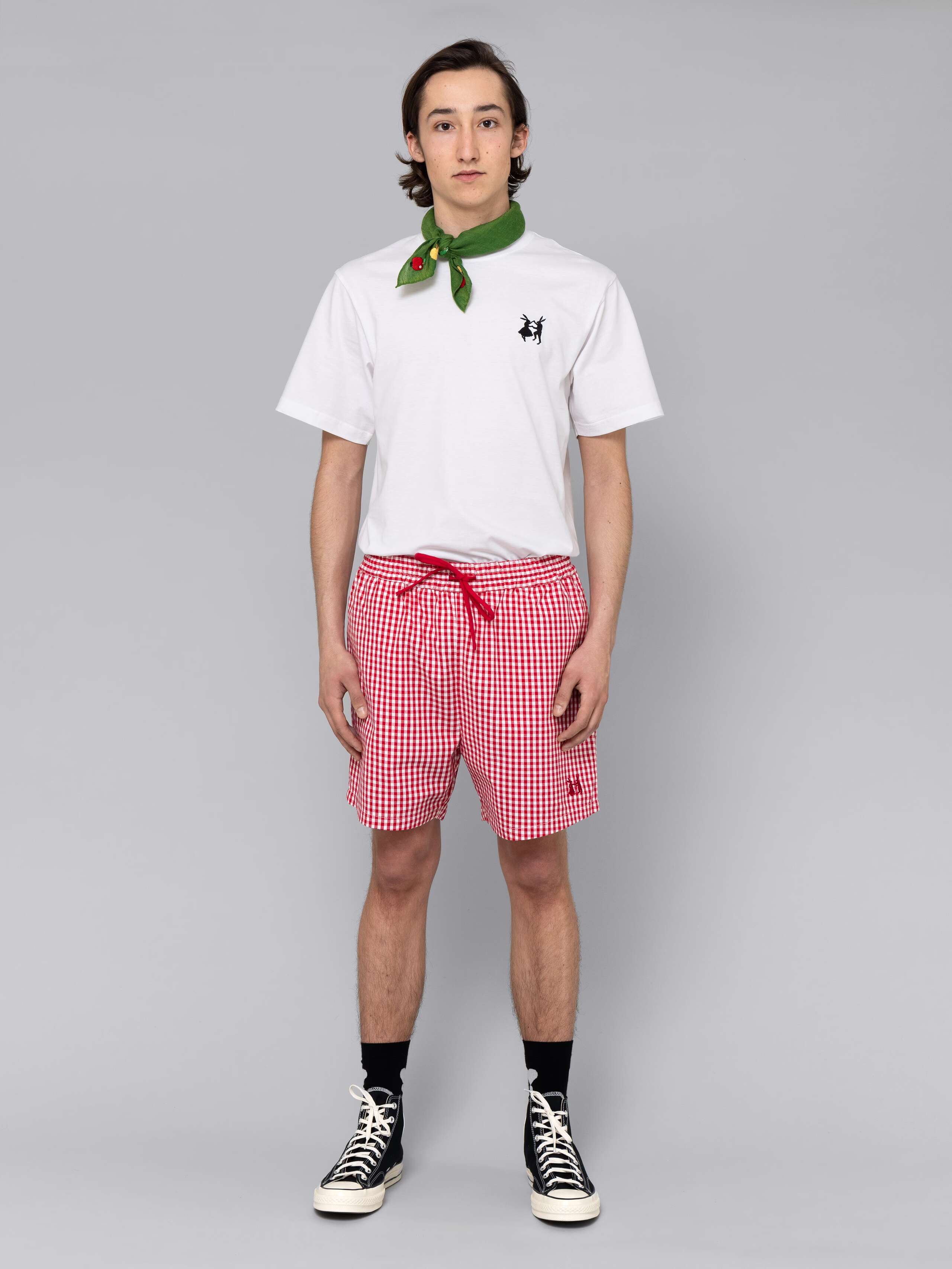 Male model is wearing a summery combination of a cotton short featuring a red vichy check pattern and a white t-shirt