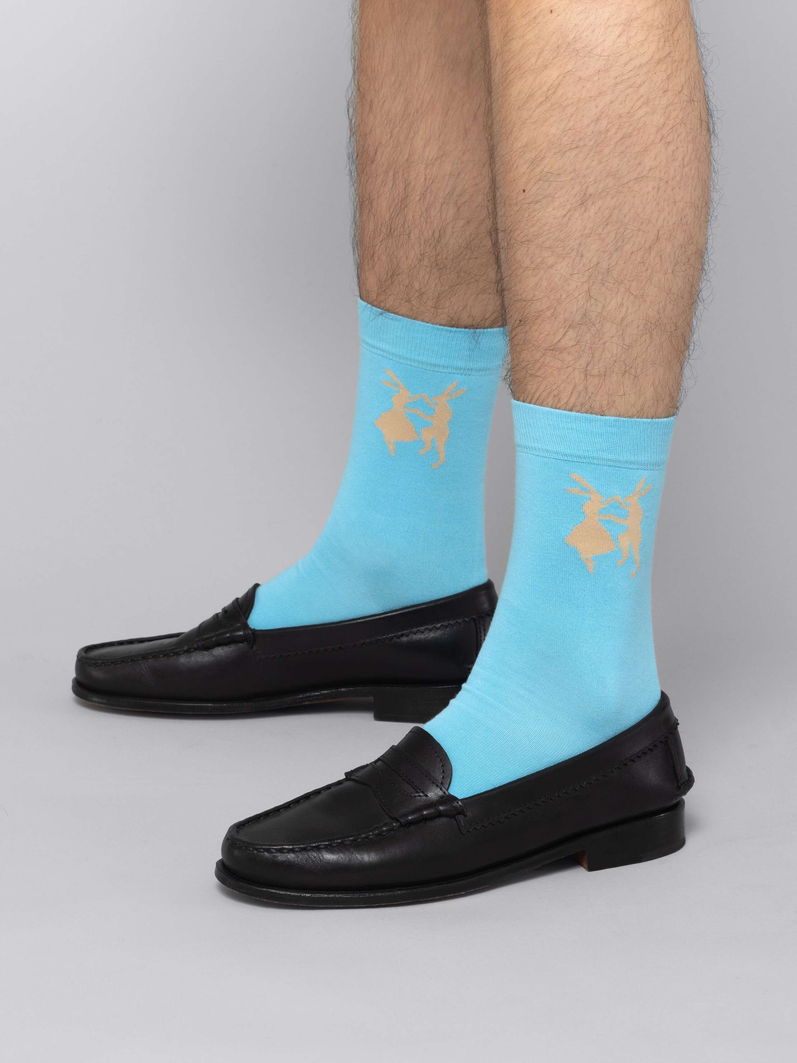Mal model is wearing blue socks with beige enSoie logo in black leather shoes