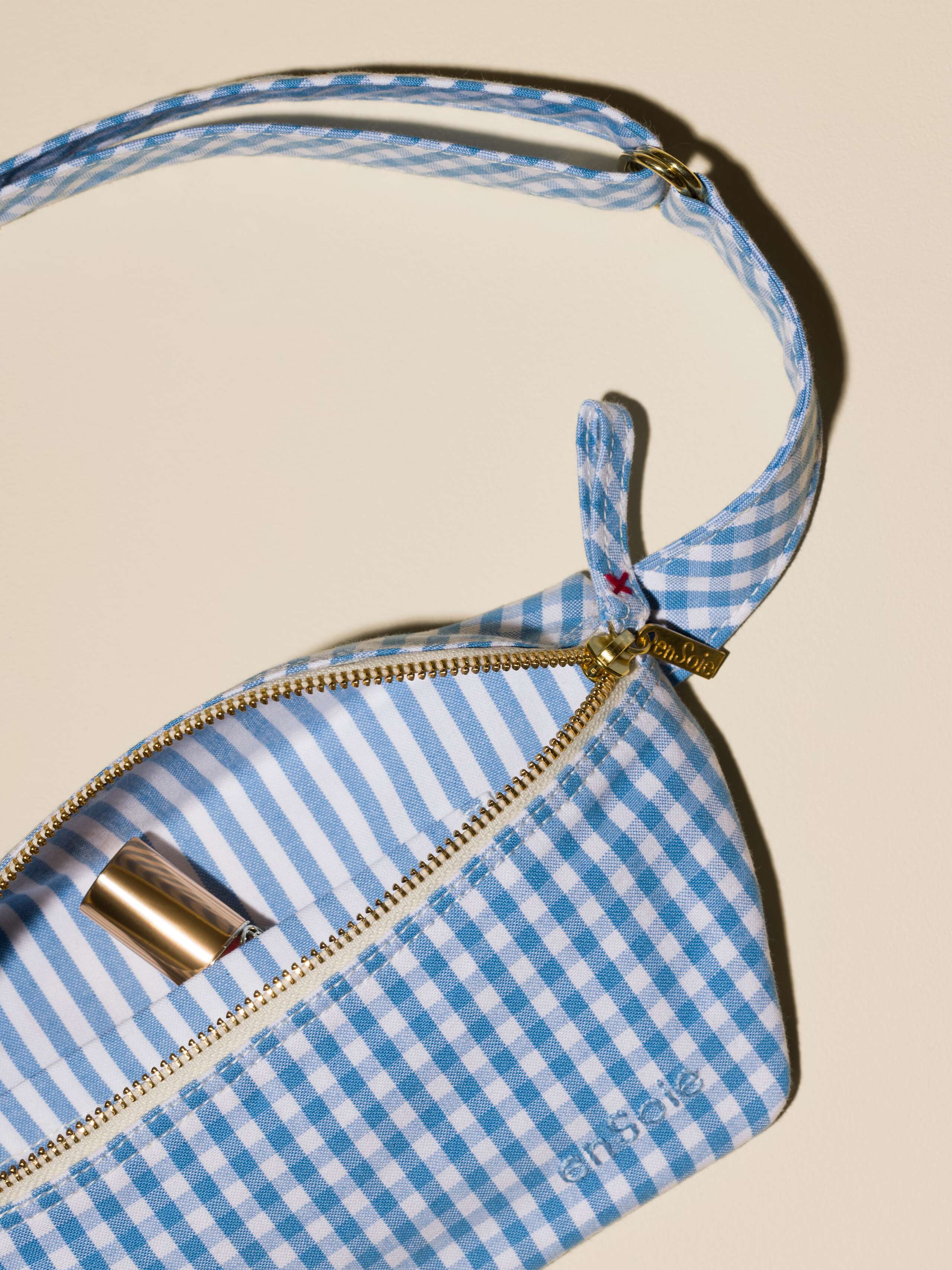 Picture of a cute cotton hip bag featuring a light blue vichy check pattern and a striped pattern